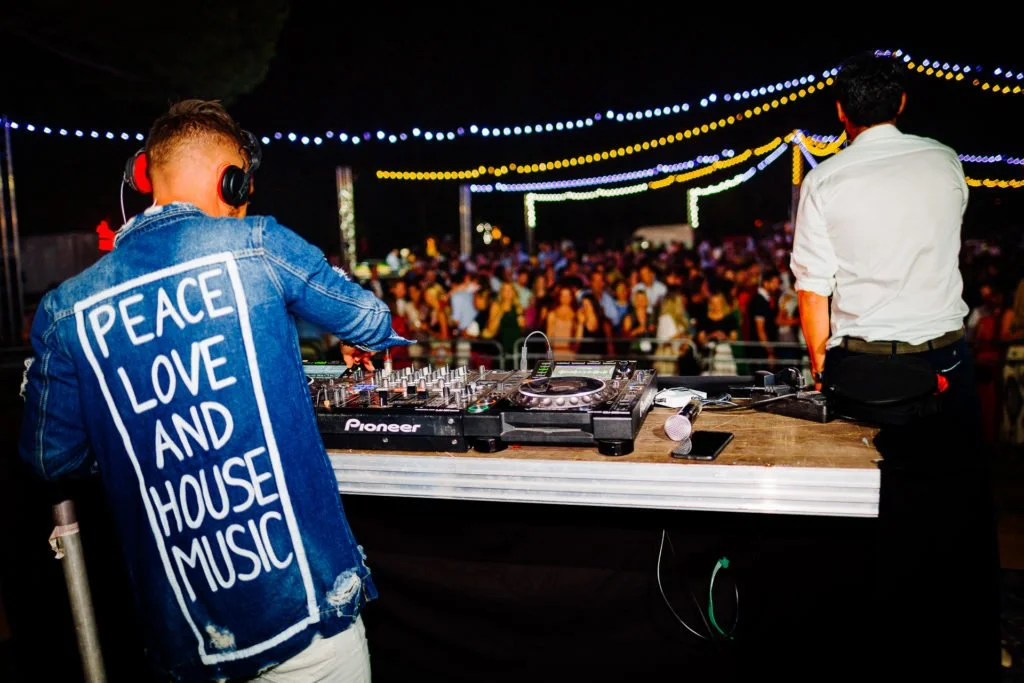 Prise de vue juste derrière le DJ qui mix devant un large public