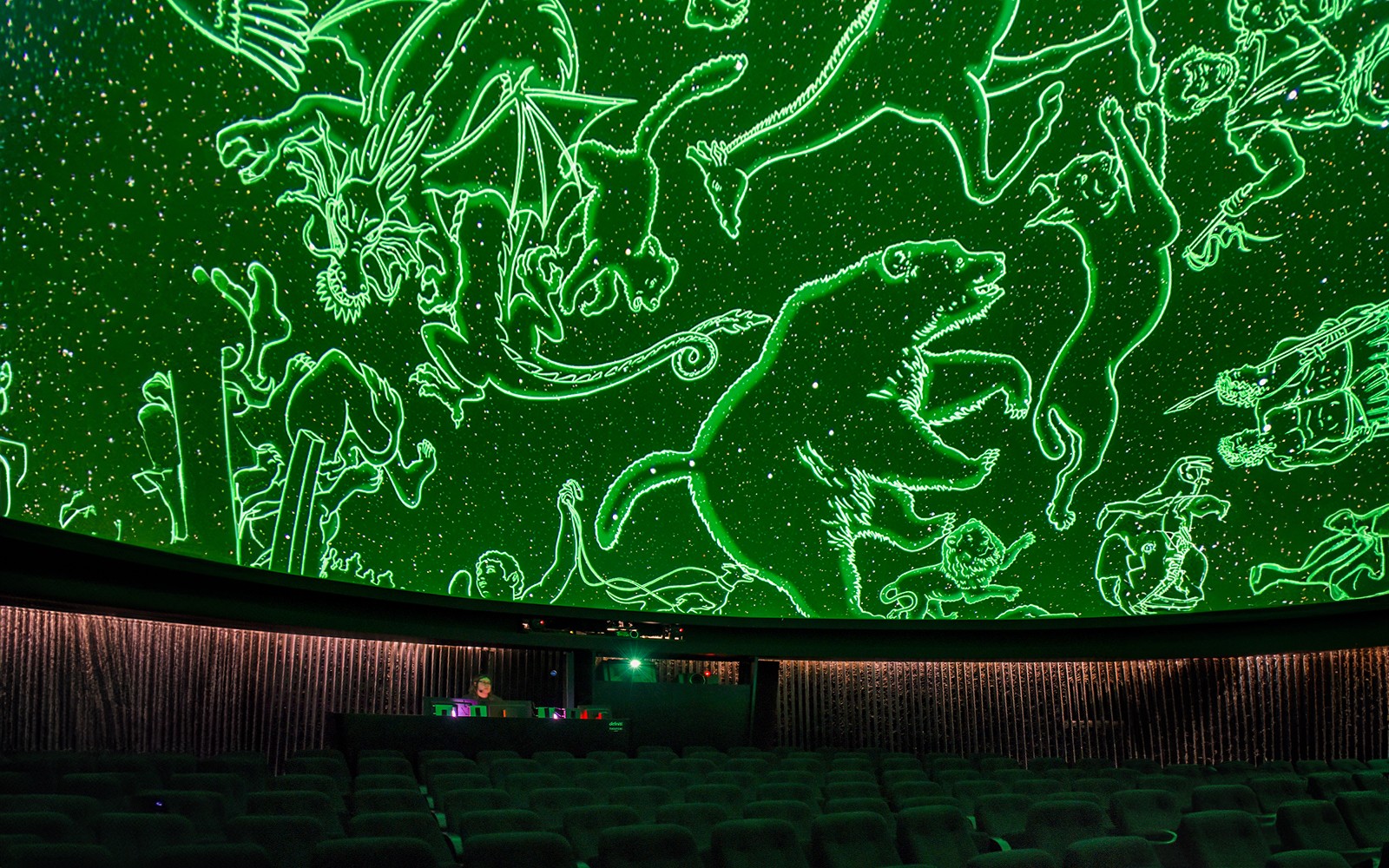 皇家天文台天文馆的内部，游客们坐在星空穹顶下。