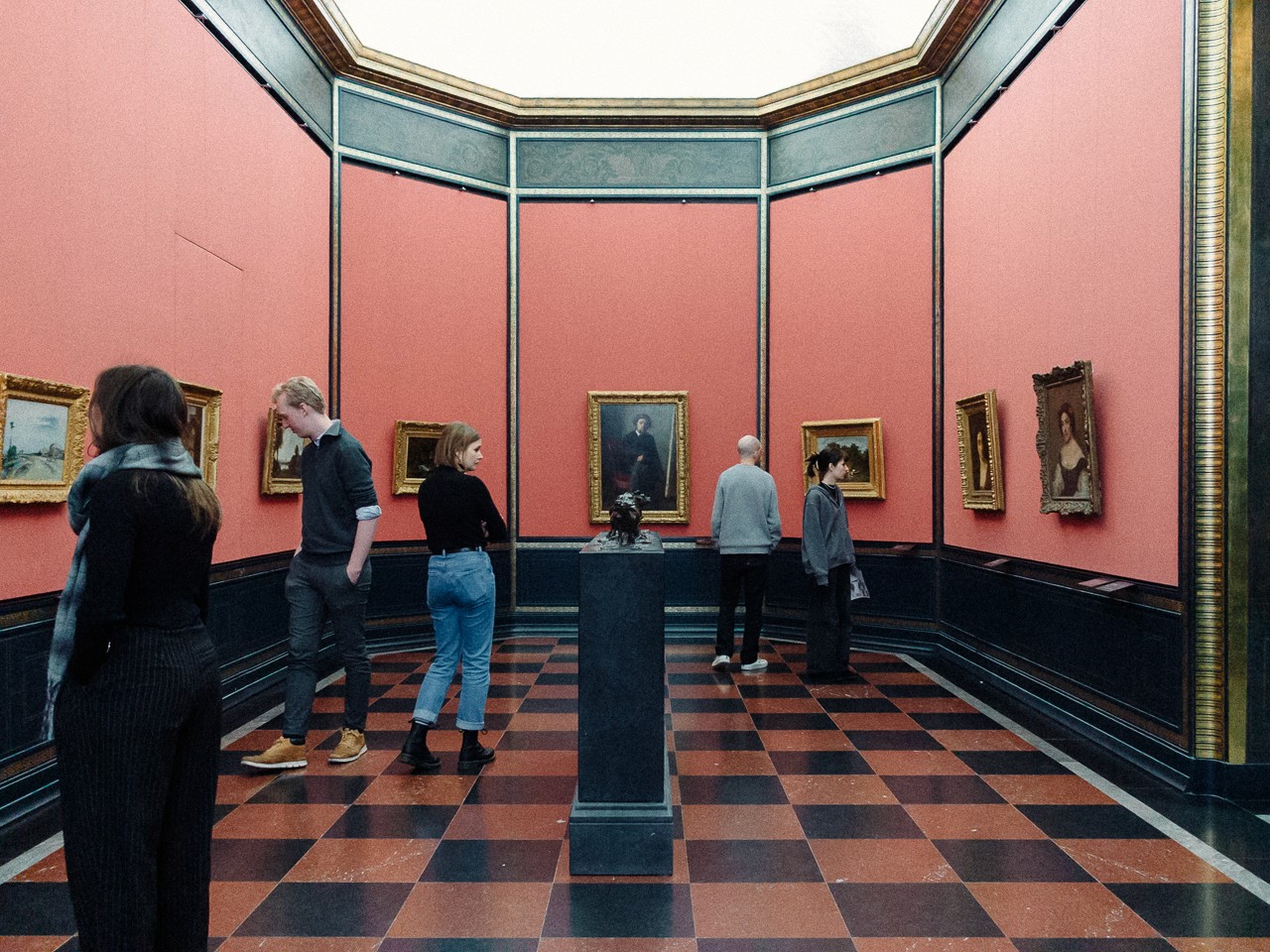 Close-up of a yellow tennis ball sitting on a green court, positioned near the white center line.