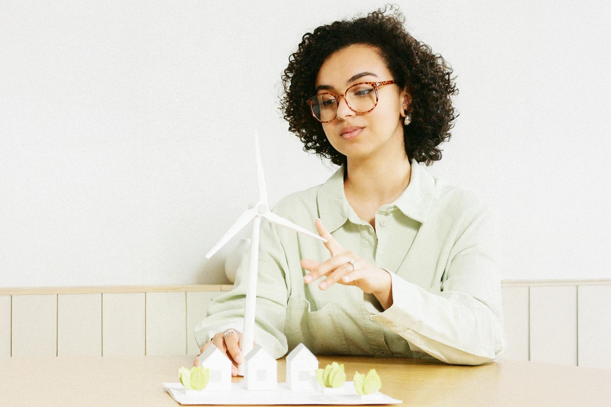 Sustainability specialist reviewing a wind turbine model, representing clean energy innovation and home efficiency solutions.