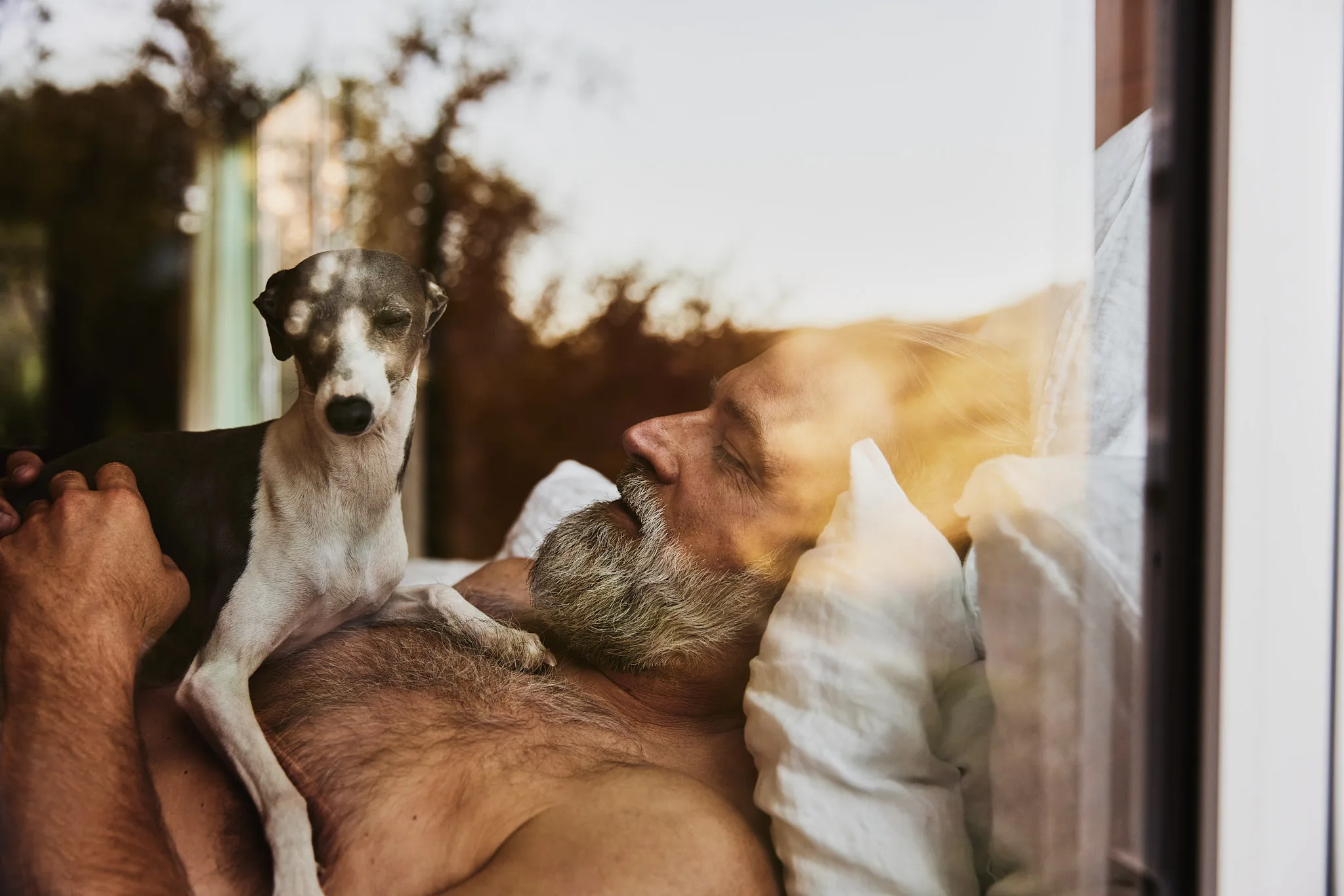 man sleeping with dog on chest — lifestyle photography by Tom Kubik