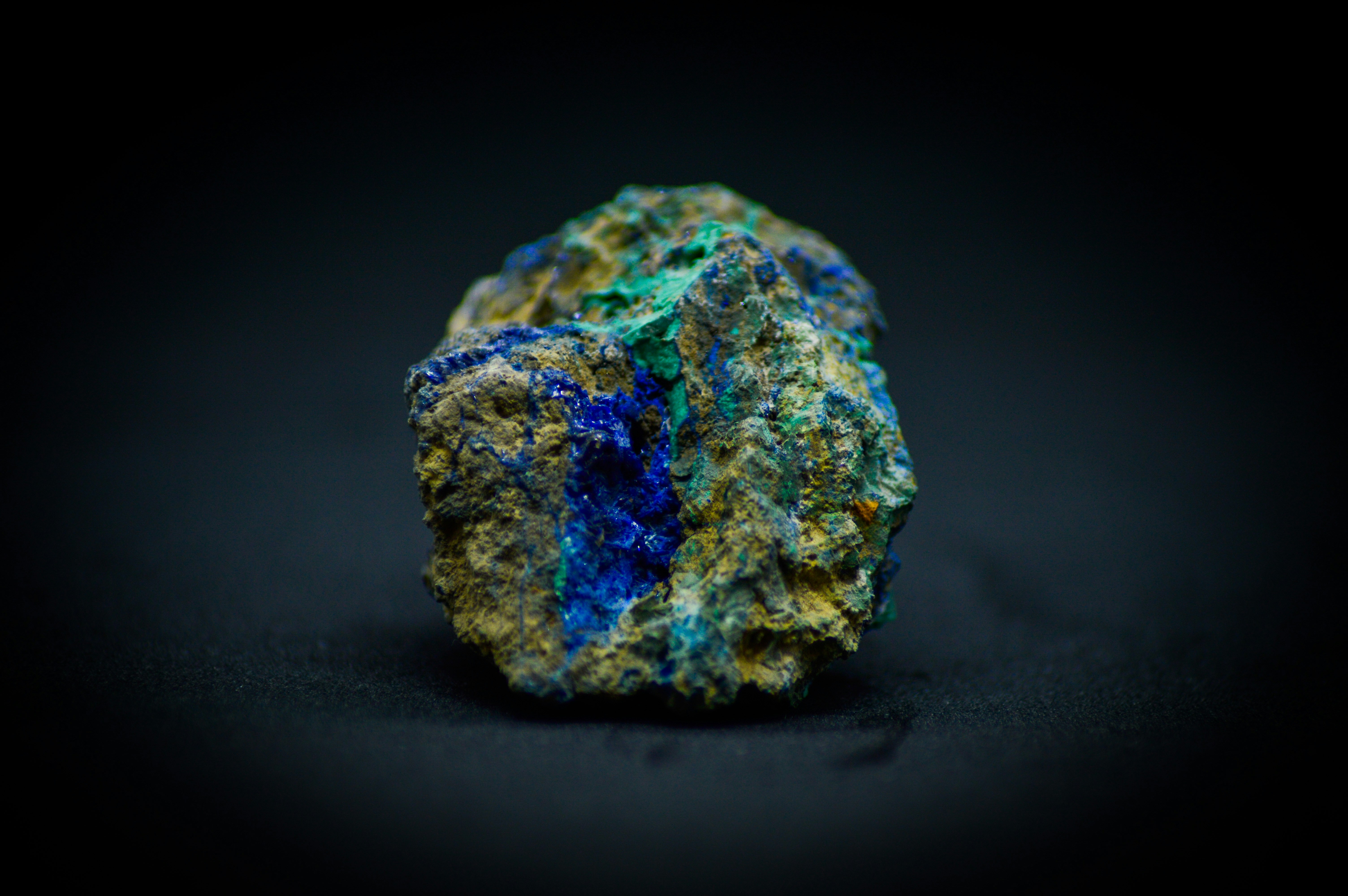 A blue and green rock on a black background