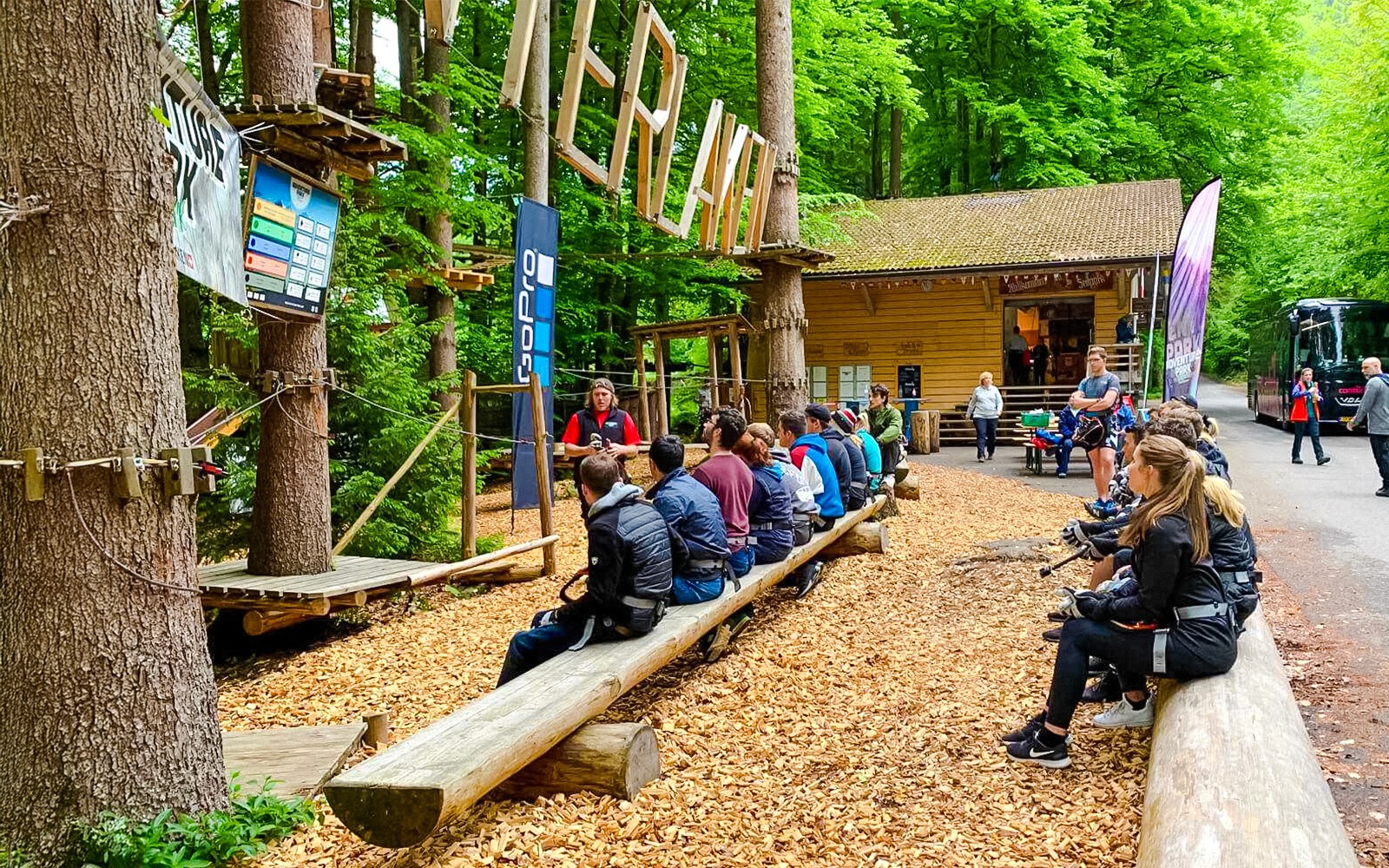 Visitors seated for a briefing at Ropes Park Interlaken, surrounded by lush forest.