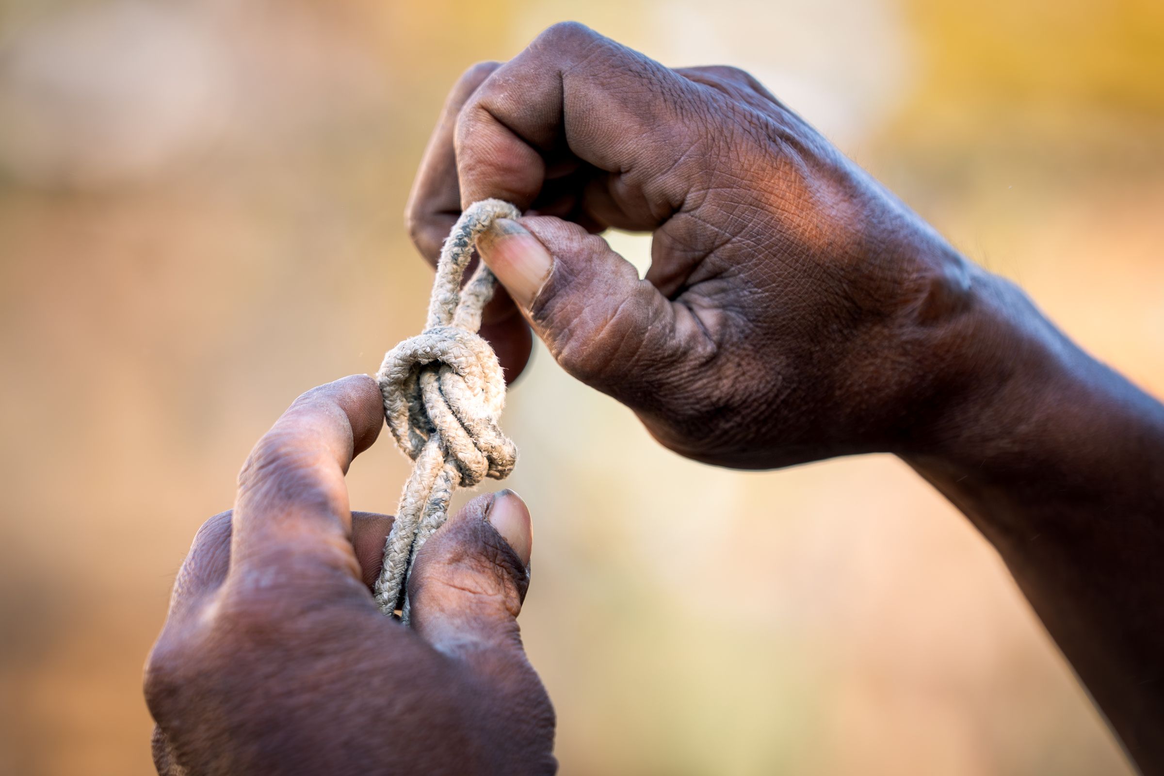 Hands tying a knot in a rope