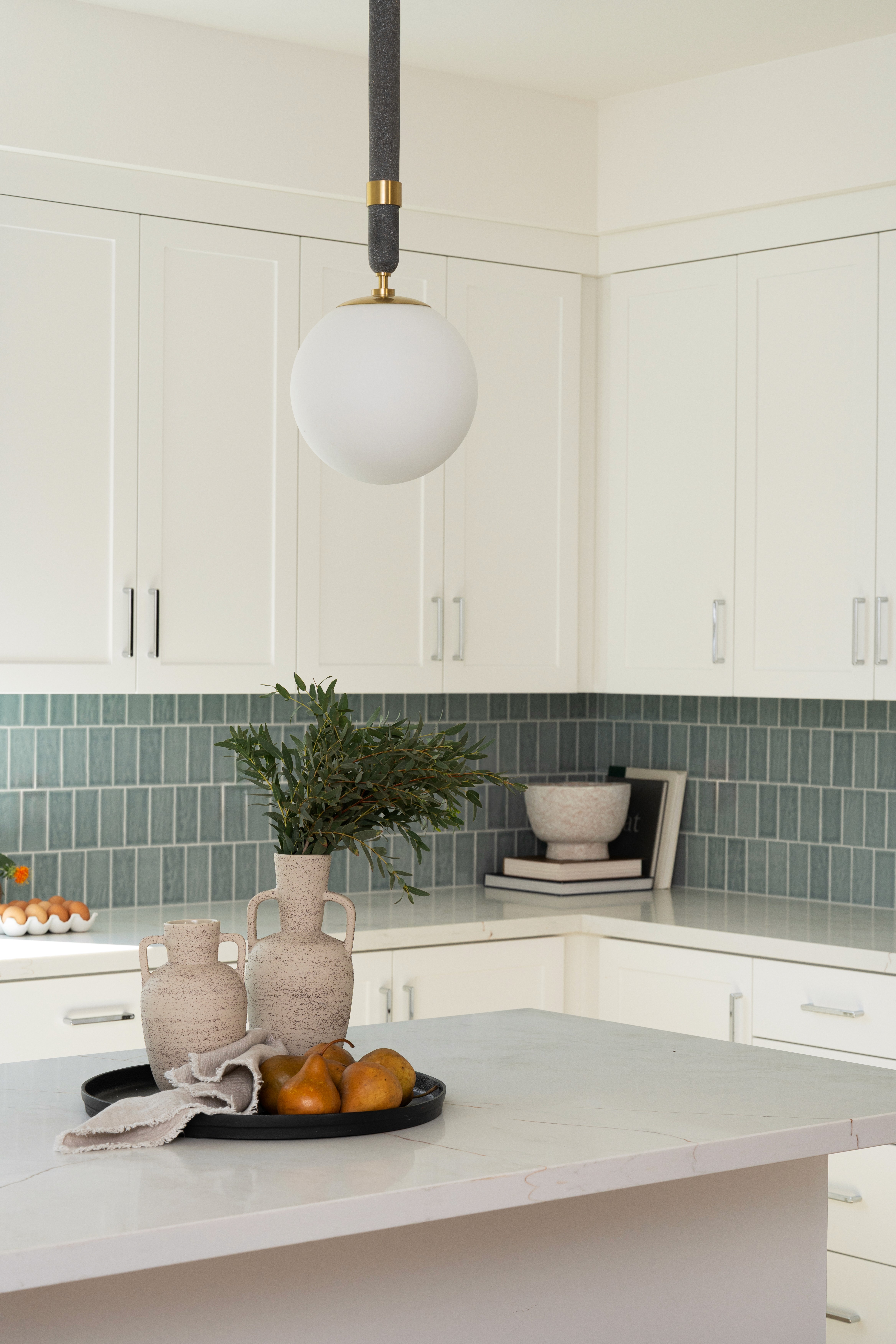 Kitchen island and back counter with decor, greenery and pendant lighting
