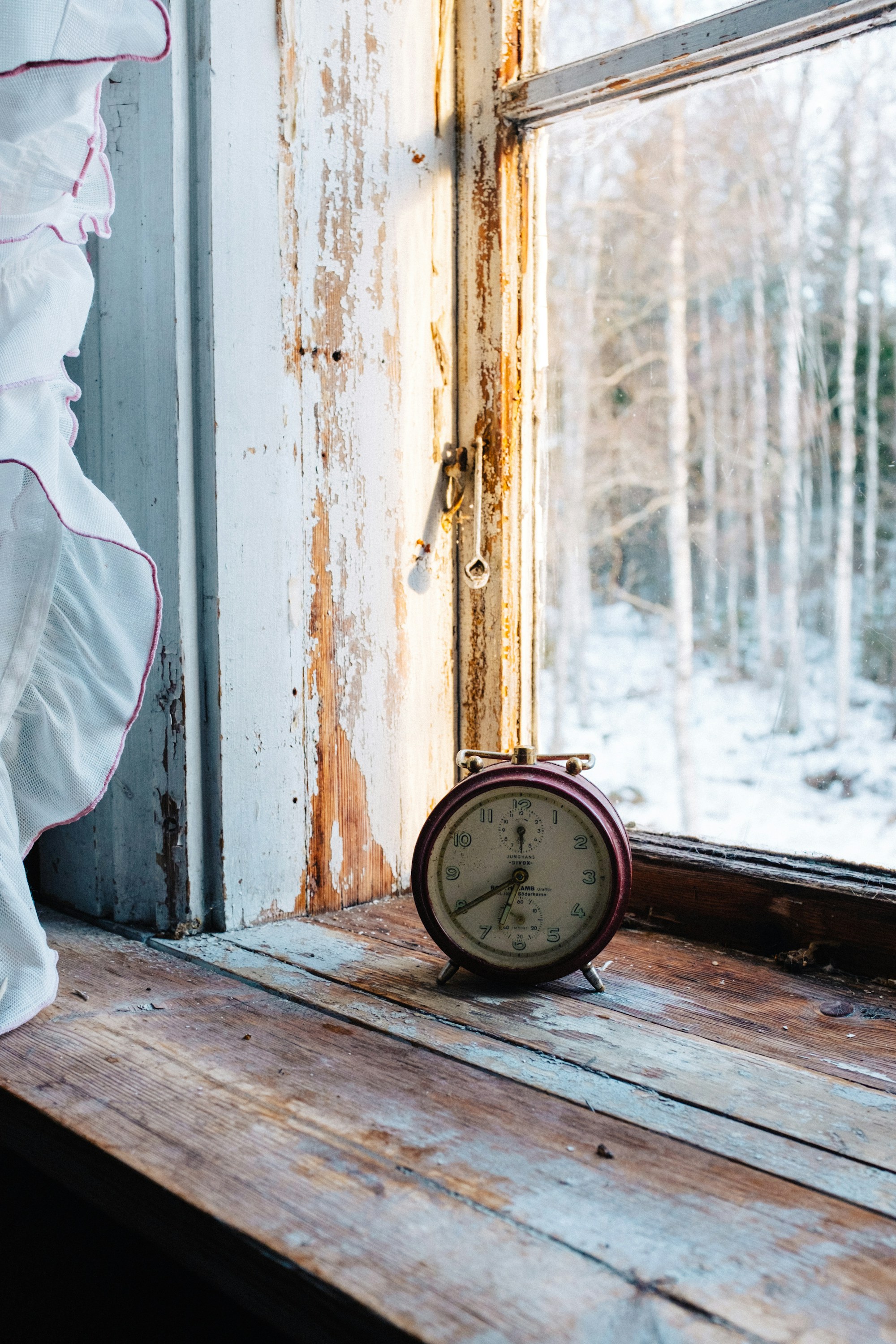 An old alarm clock on a window sill