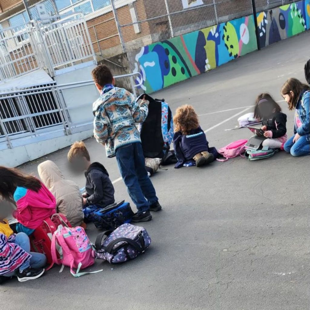 Children on a playground use their iPads rather than play together