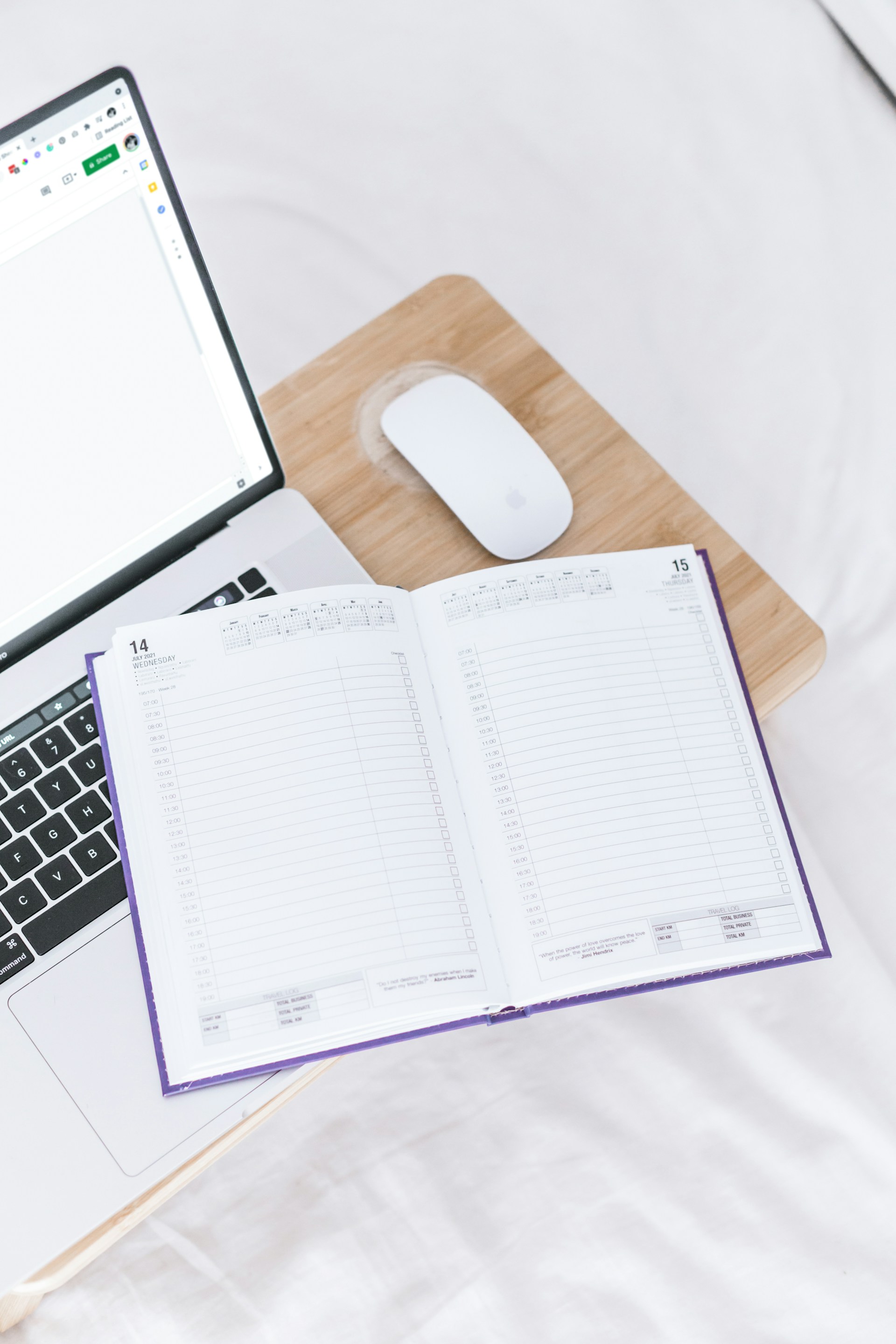 Agenda ouvert posé à côté d'un ordinateur portable, symbolisant la gestion d'agenda et l'organisation du quotidien professionnel