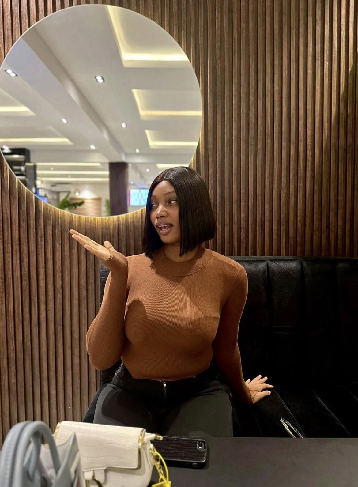 woman wearing red long-sleeved shirt beside wall