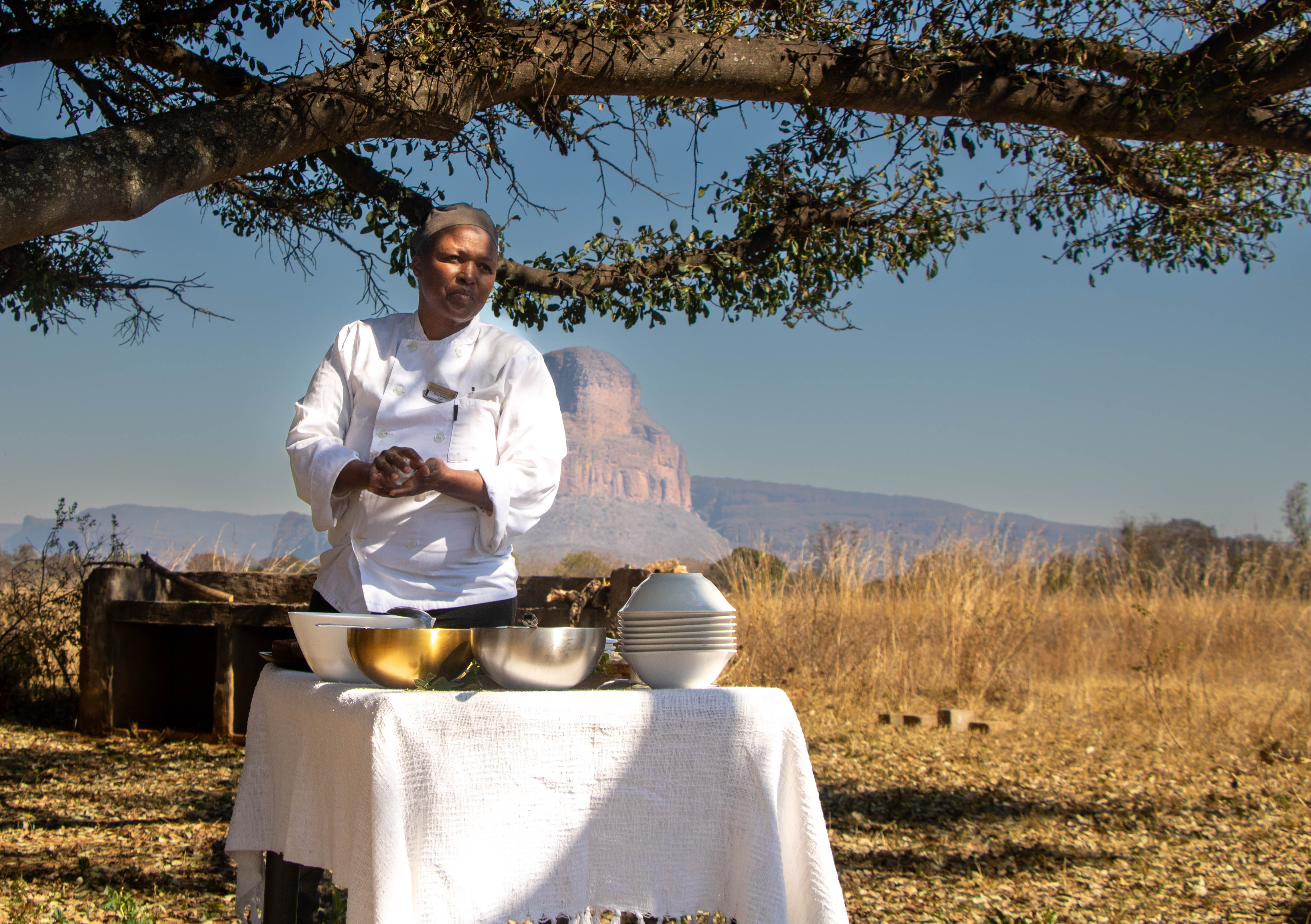 African Explorer, Botswana. En lång rad gnuer rör sig över slätterna med ryttarna i bakgrunden – ett klassiskt motiv från en ridsemester i Botswana.
