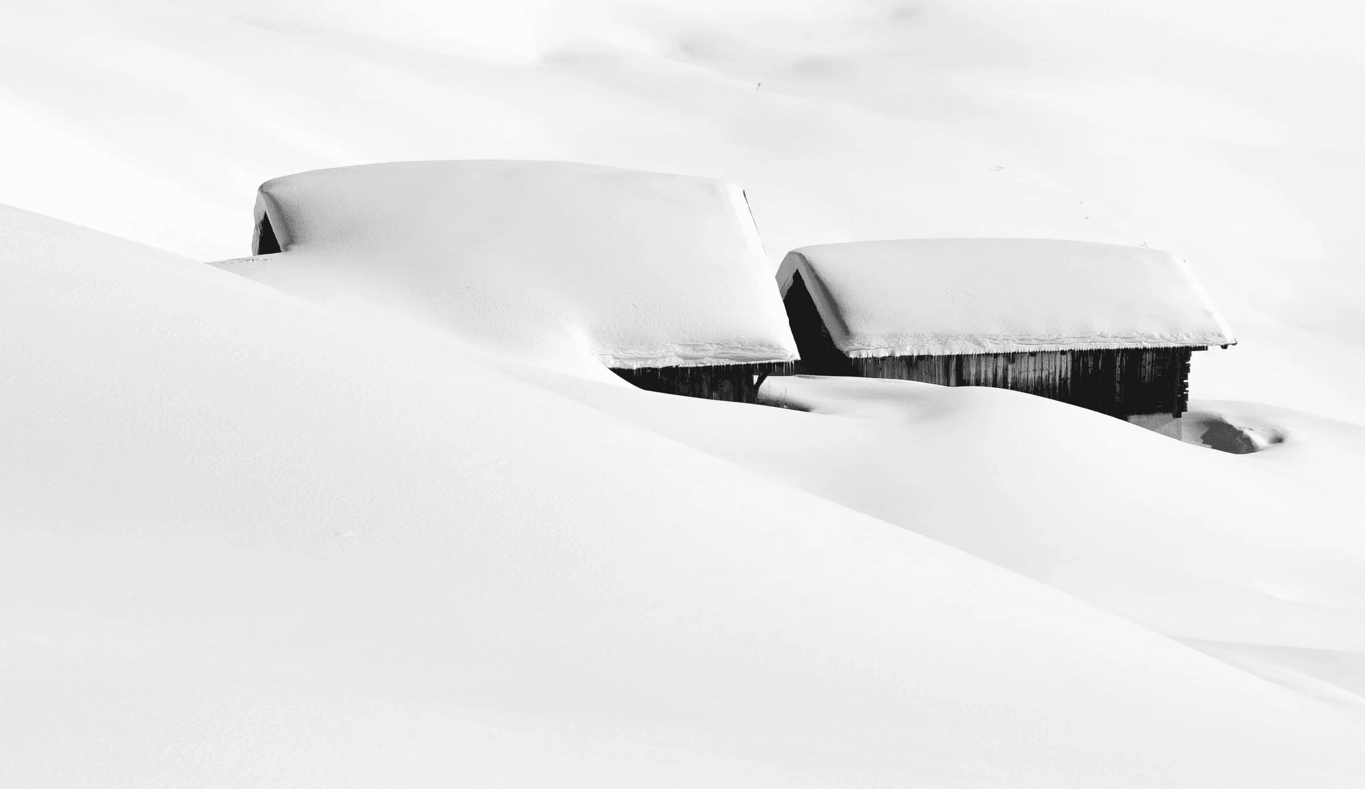 a black and white photo of a snow covered hill