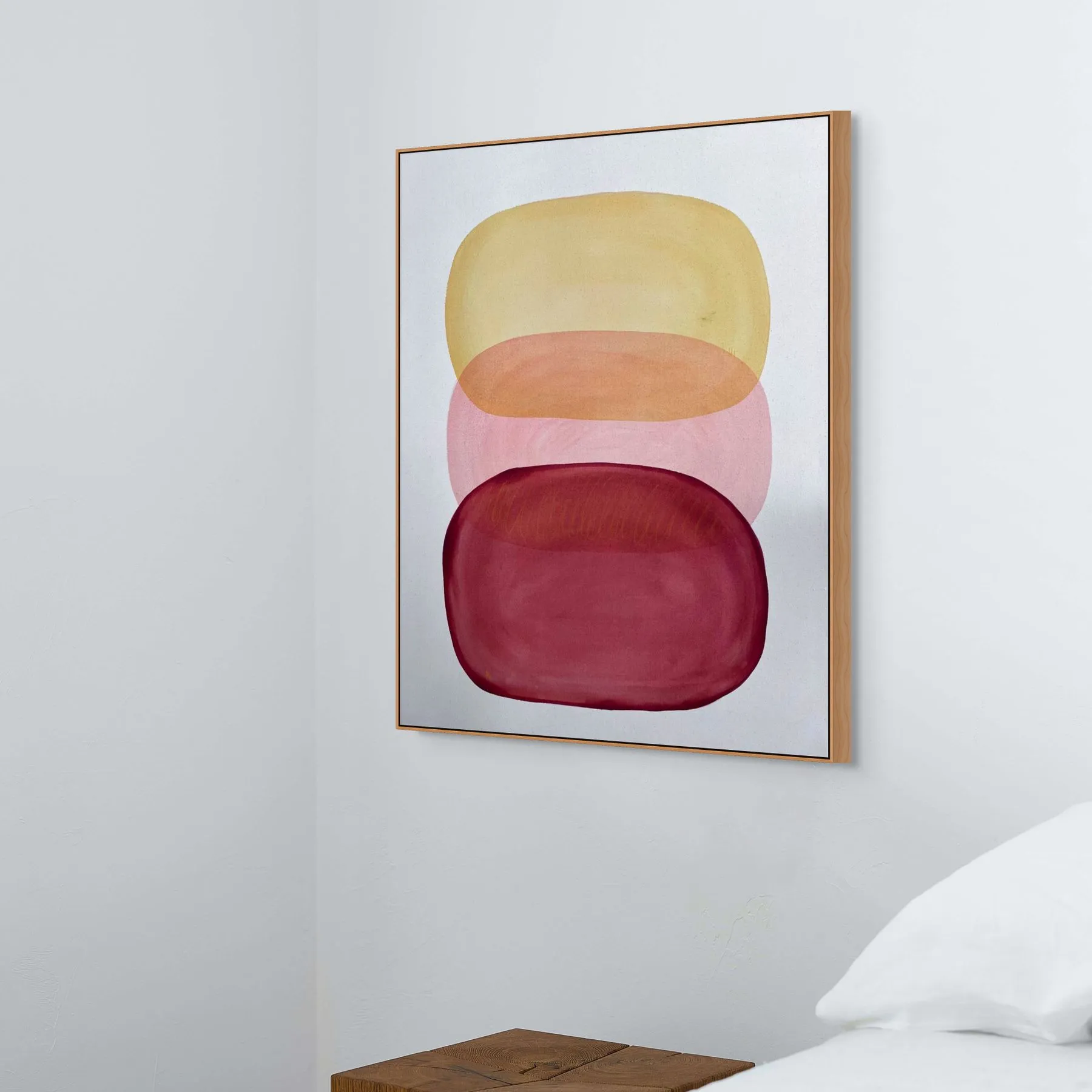 Abstract art piece featuring layered colors of yellow, orange, and red, framed and hung on a white wall.