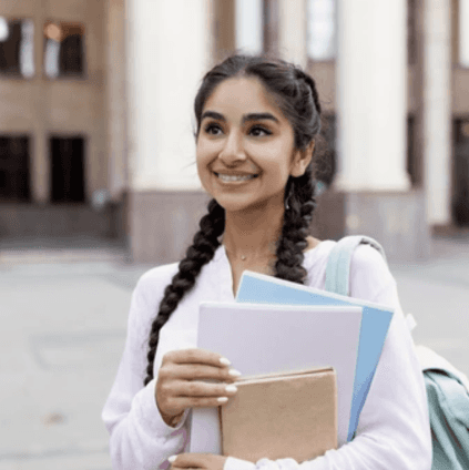 Girl holding textbooks at her school