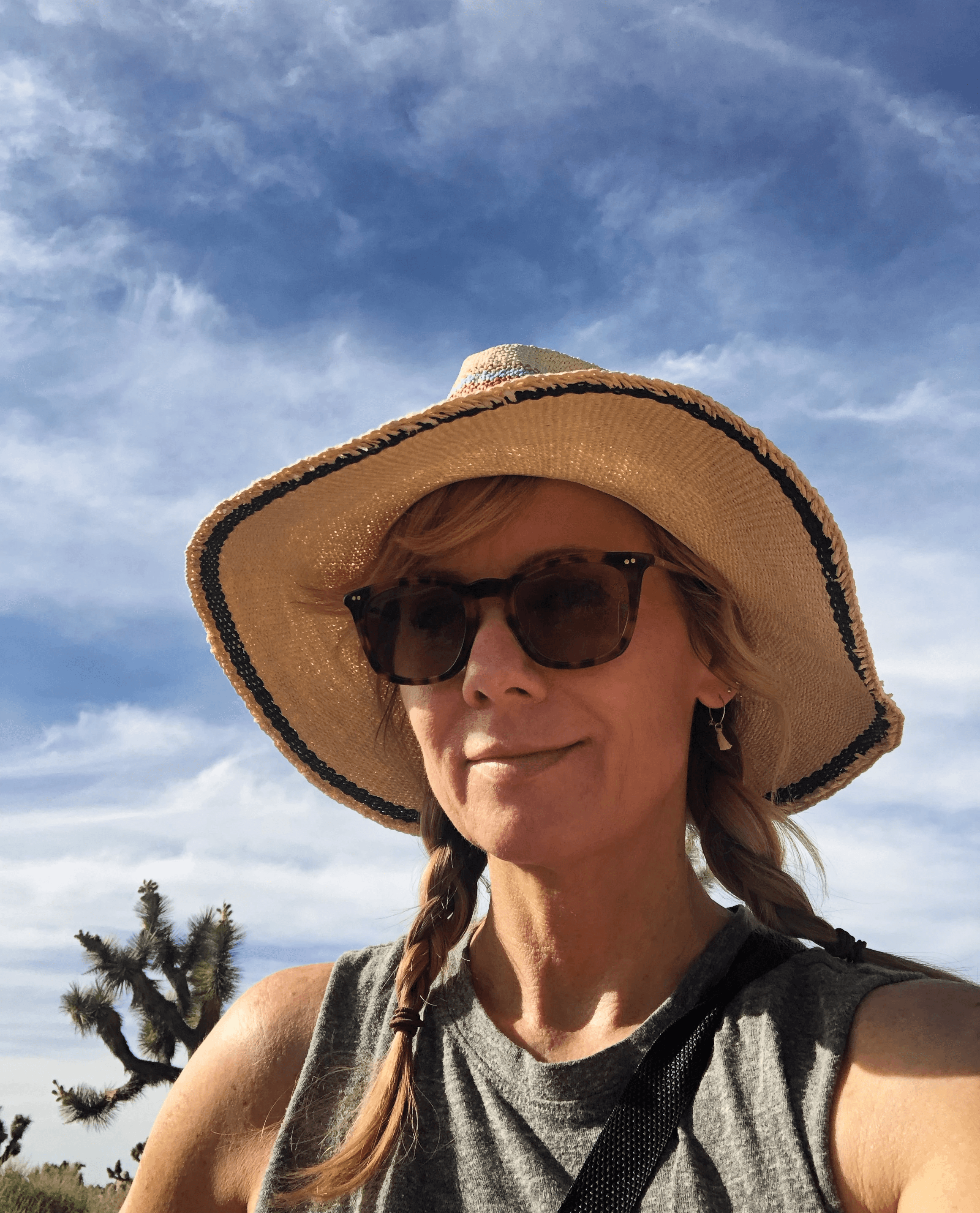 A model wearing an elegant cream blazer sits on a chair against a bright blue background, showcasing a modern and minimalist professional style.