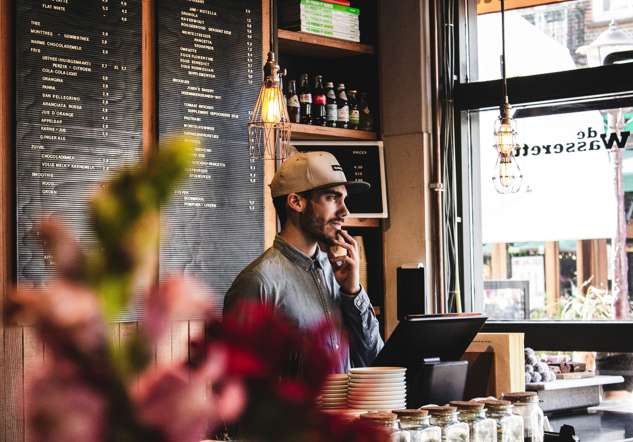 Coffee shop barista behind the counter ready to serve customers