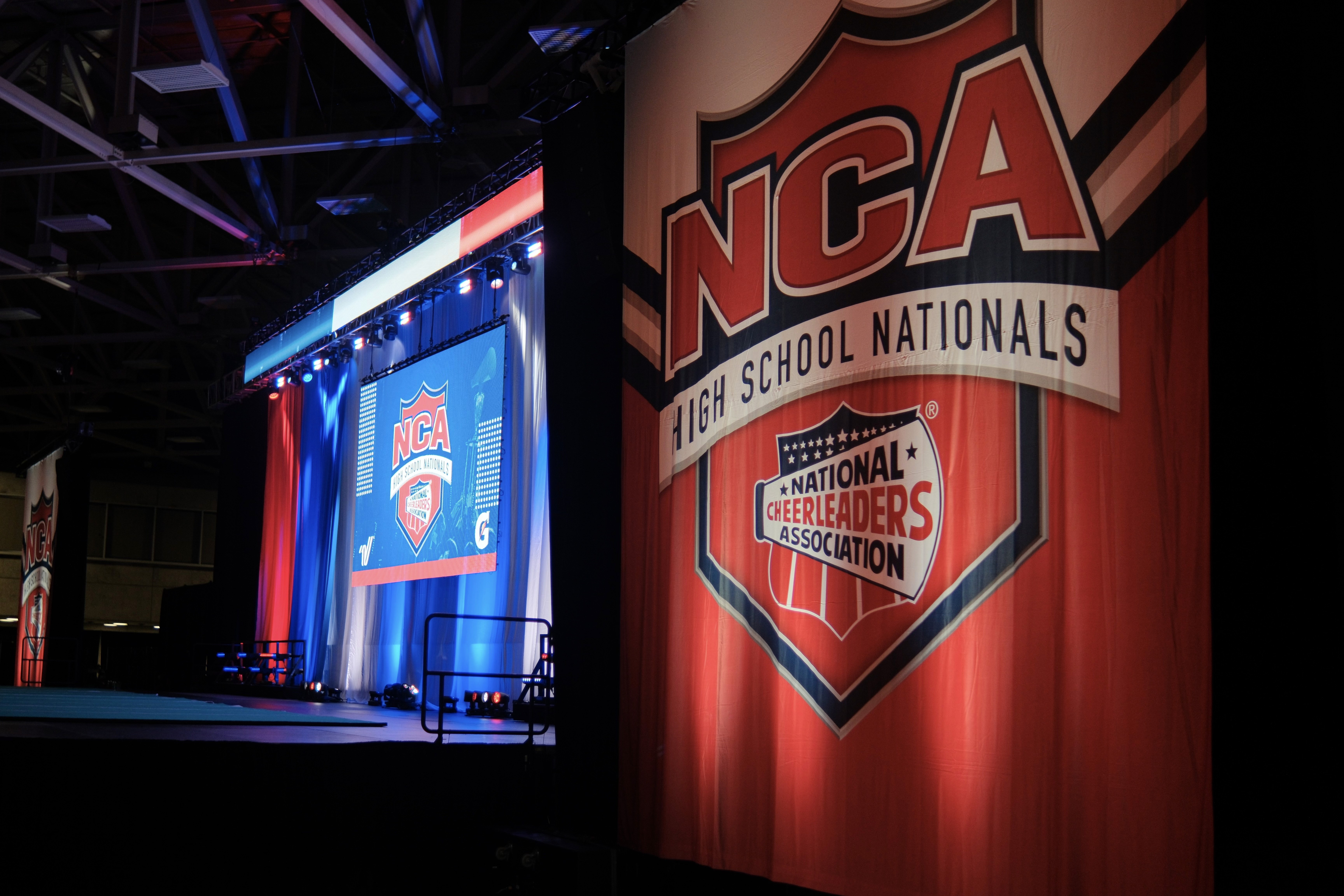 Large National Cheerleaders Association branded backdrop at NCA High School Nationals, Dallas — event staging by UpLight Technologies