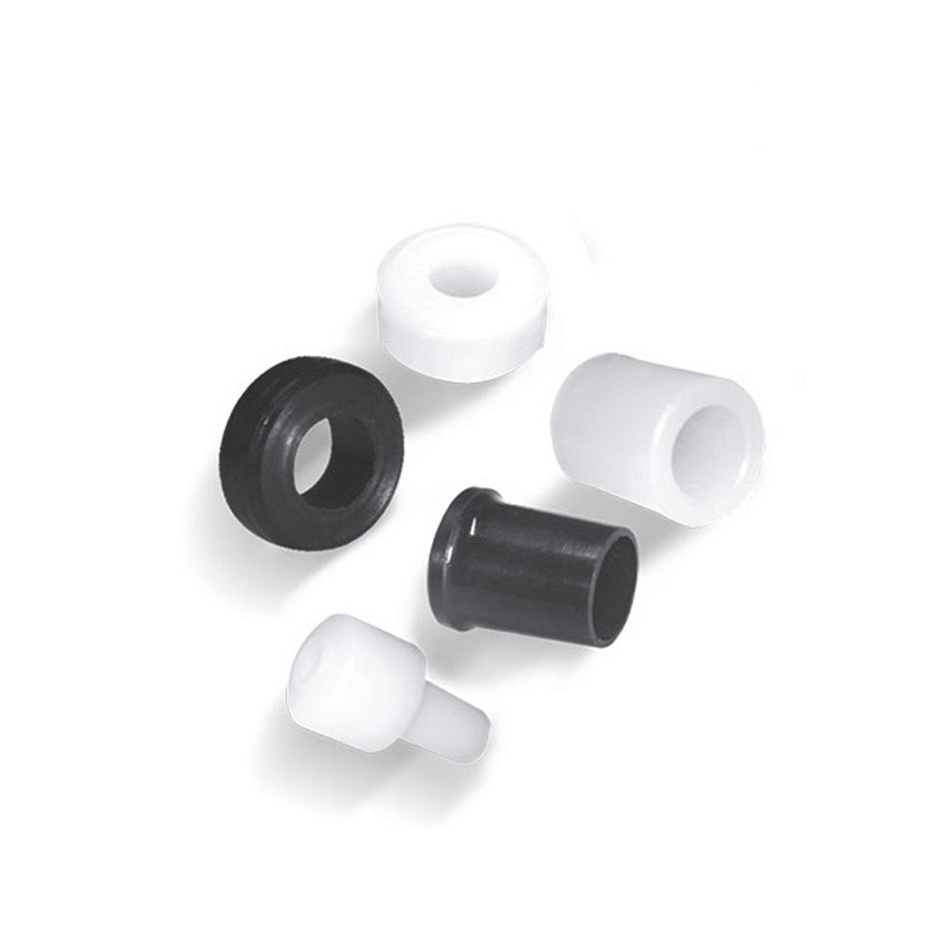 Six small cylindrical plastic components in black and white, each with hollow centers and varied shapes.arrier chain with yellow circular accents, partially filled with cables.