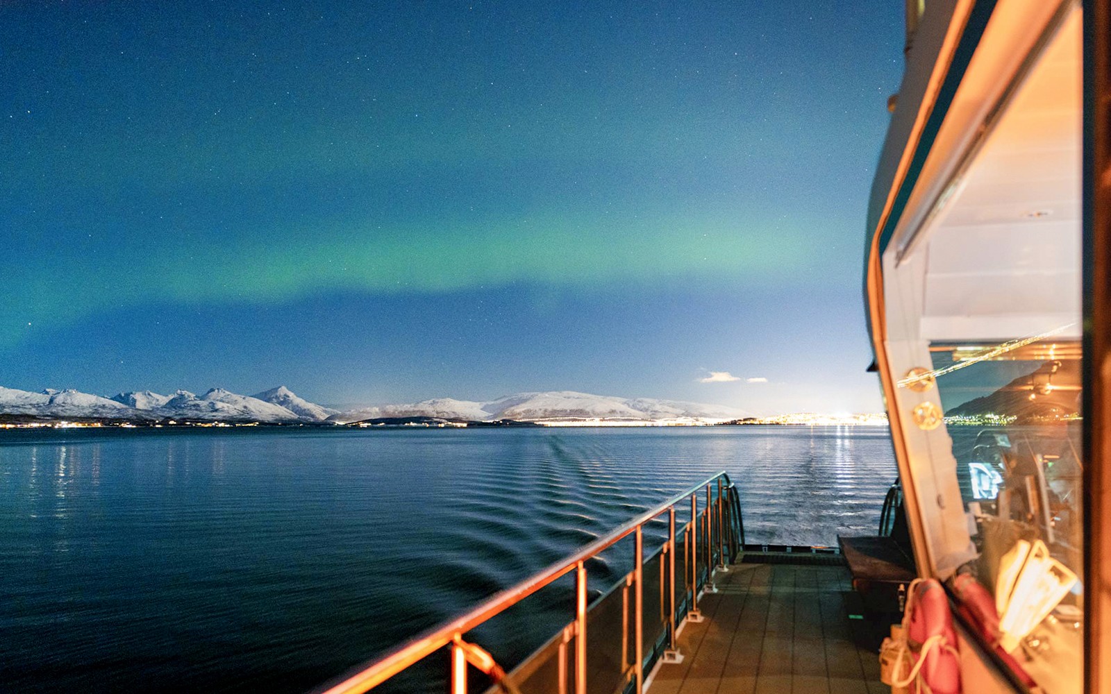 Cruise ship deck under Northern Lights near Tromso, Norway.