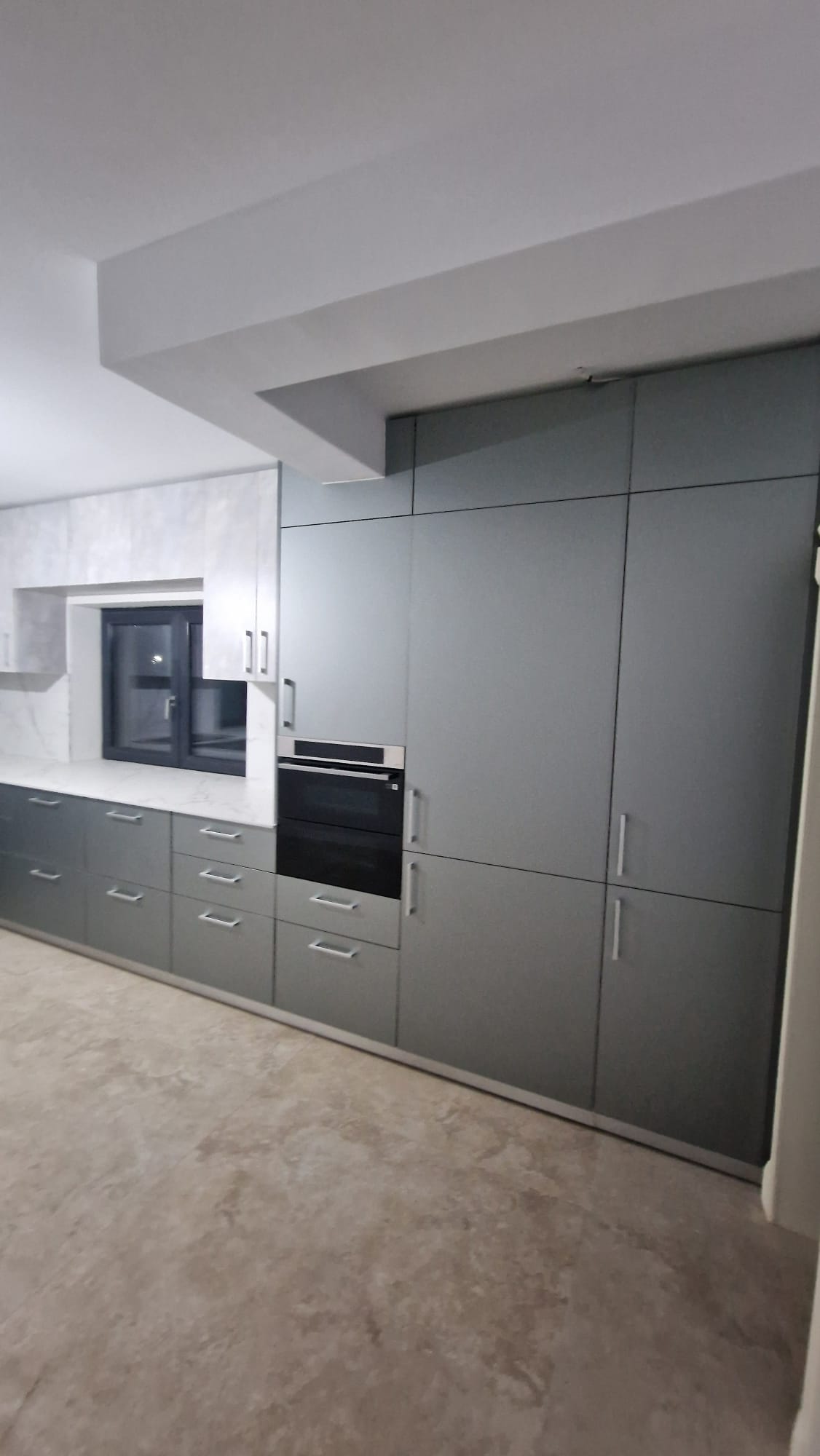 Dormitor cu dulapuri bej și oglinzi încorporate, comodă asortată și lumini calde.