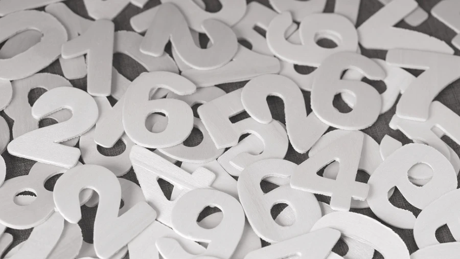 Pile of white three-dimensional numbers scattered randomly, symbolizing data, measurement, and analytics.