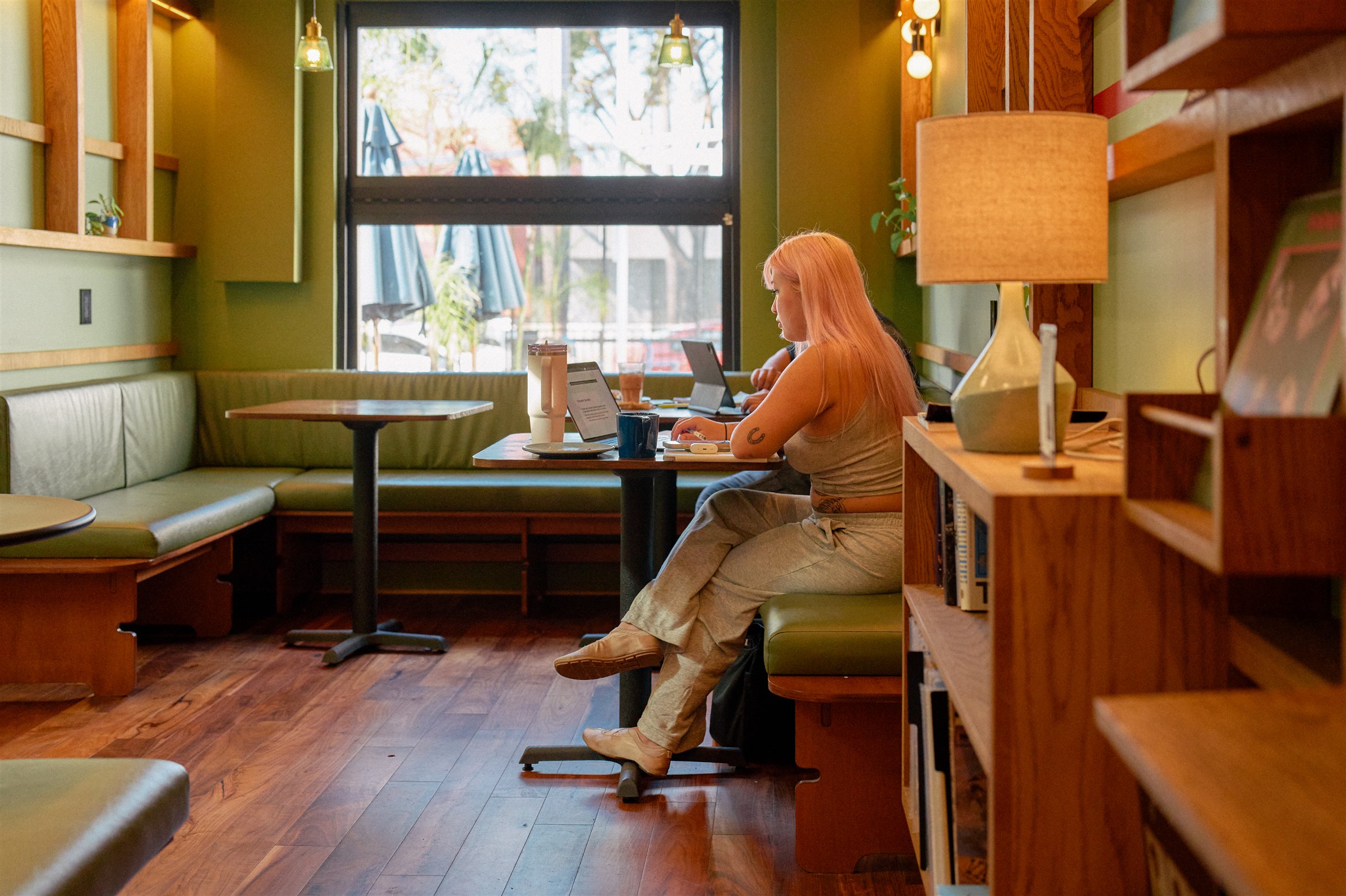 Dedo Coffee listening room with green banquette, timber acoustic wall and warm daylight