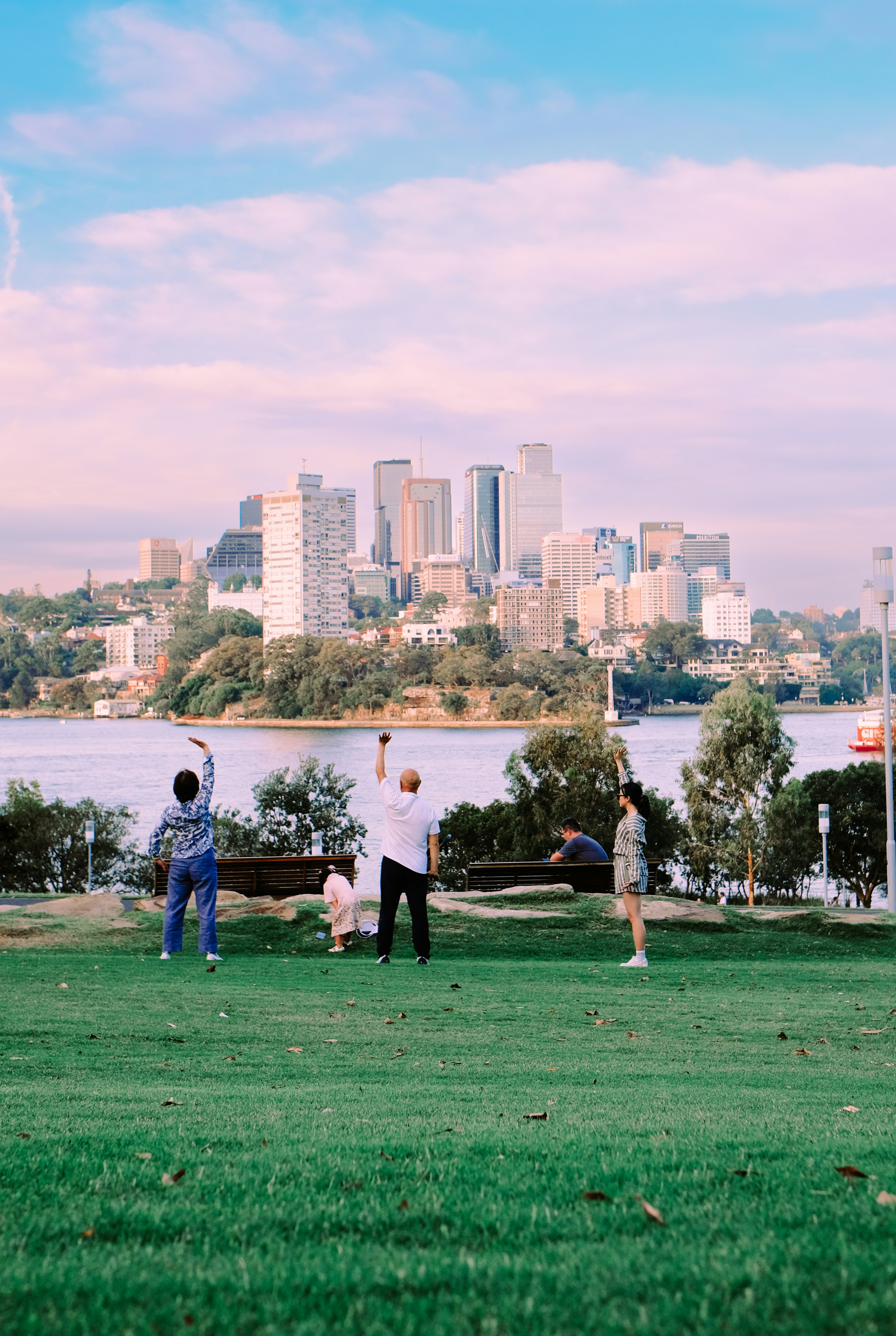 People exercising in a park with city skyline background