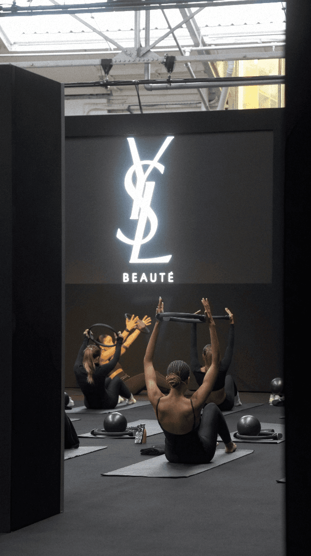Woman in black outfit sitting on bar stool, leg extended