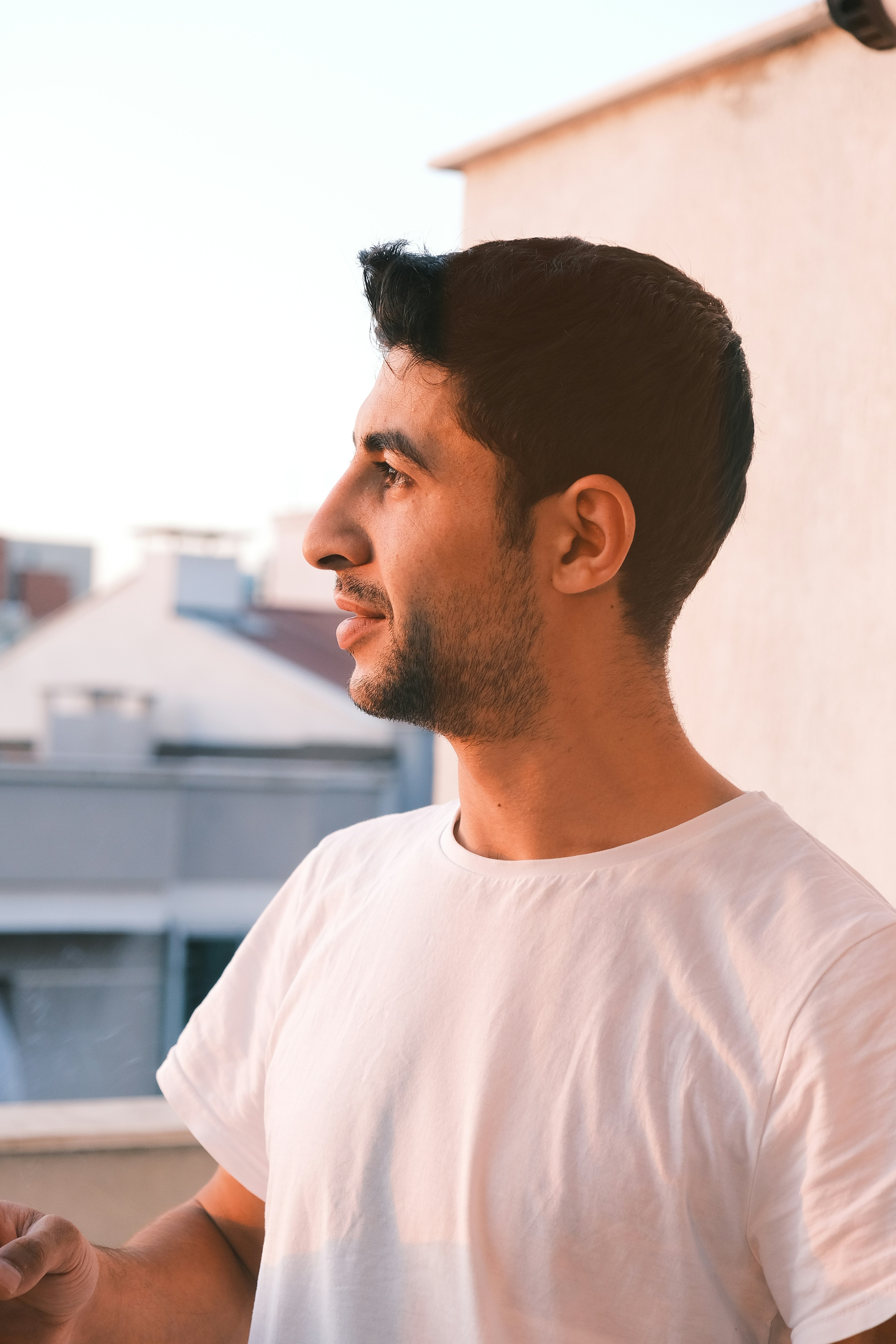 Young man looks out from a rooftop.
