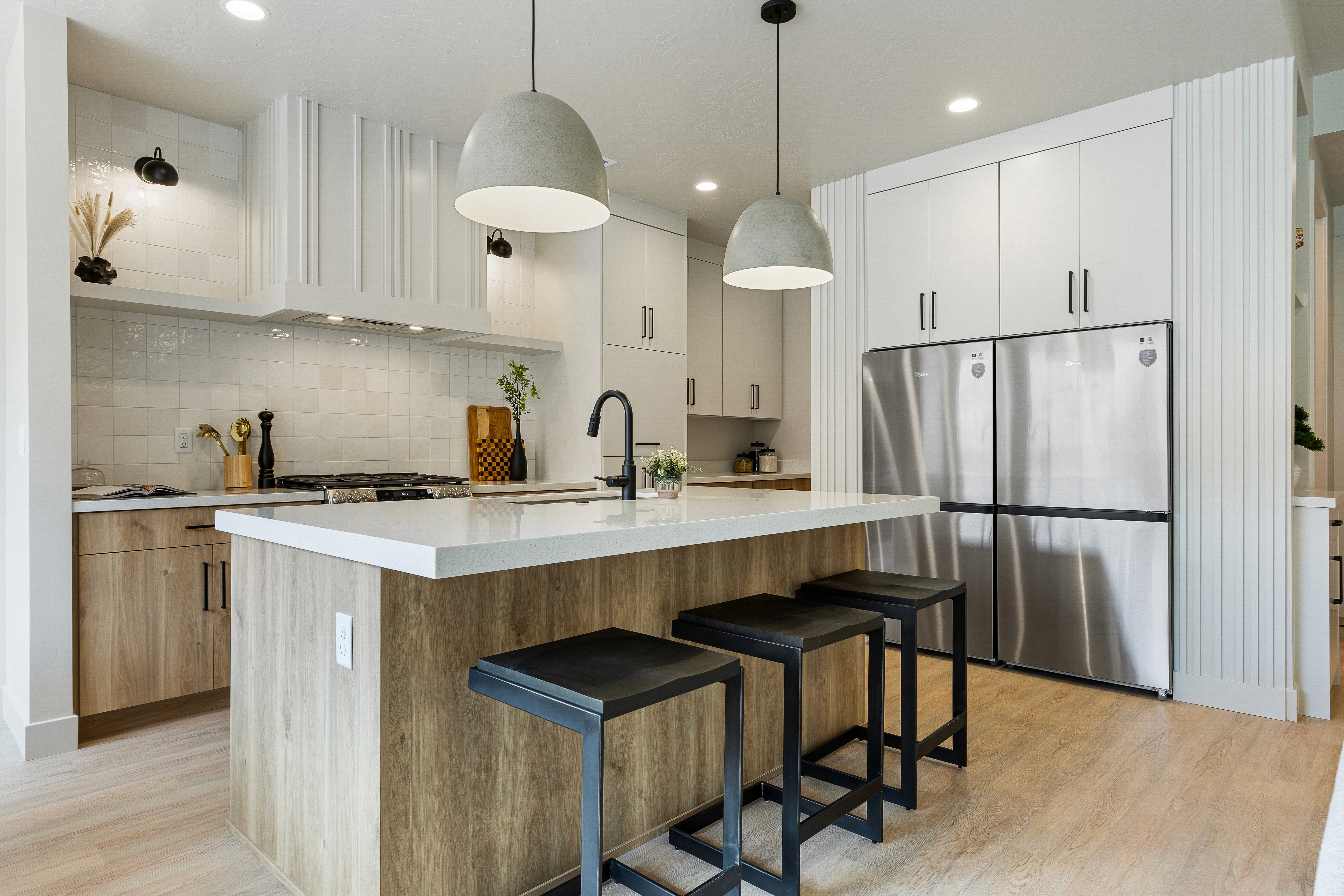 Kitchen with white cabinetry, wood island, tile backsplash, and stainless refrigerator in a Hurricane, Utah home