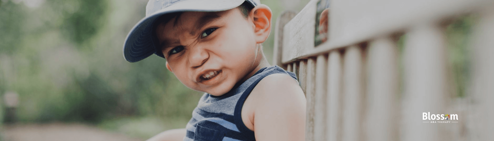 Boy with autism sitting on a bench making a scrunched-up face, experiencing autistic shutdown in VA.