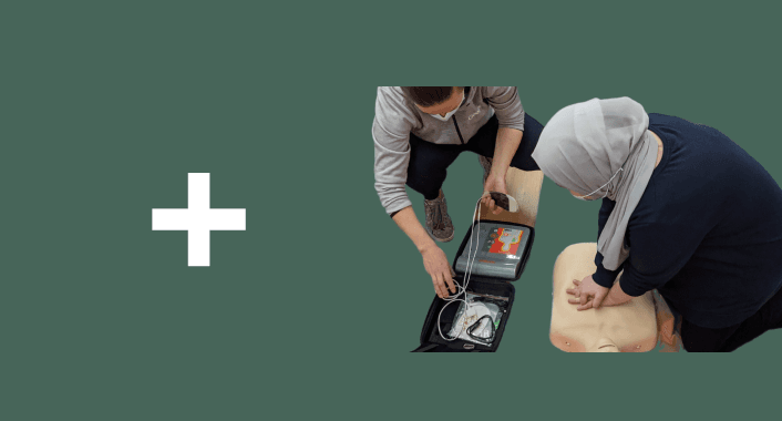 First aid training with CPR dummy and defibrillator kit.