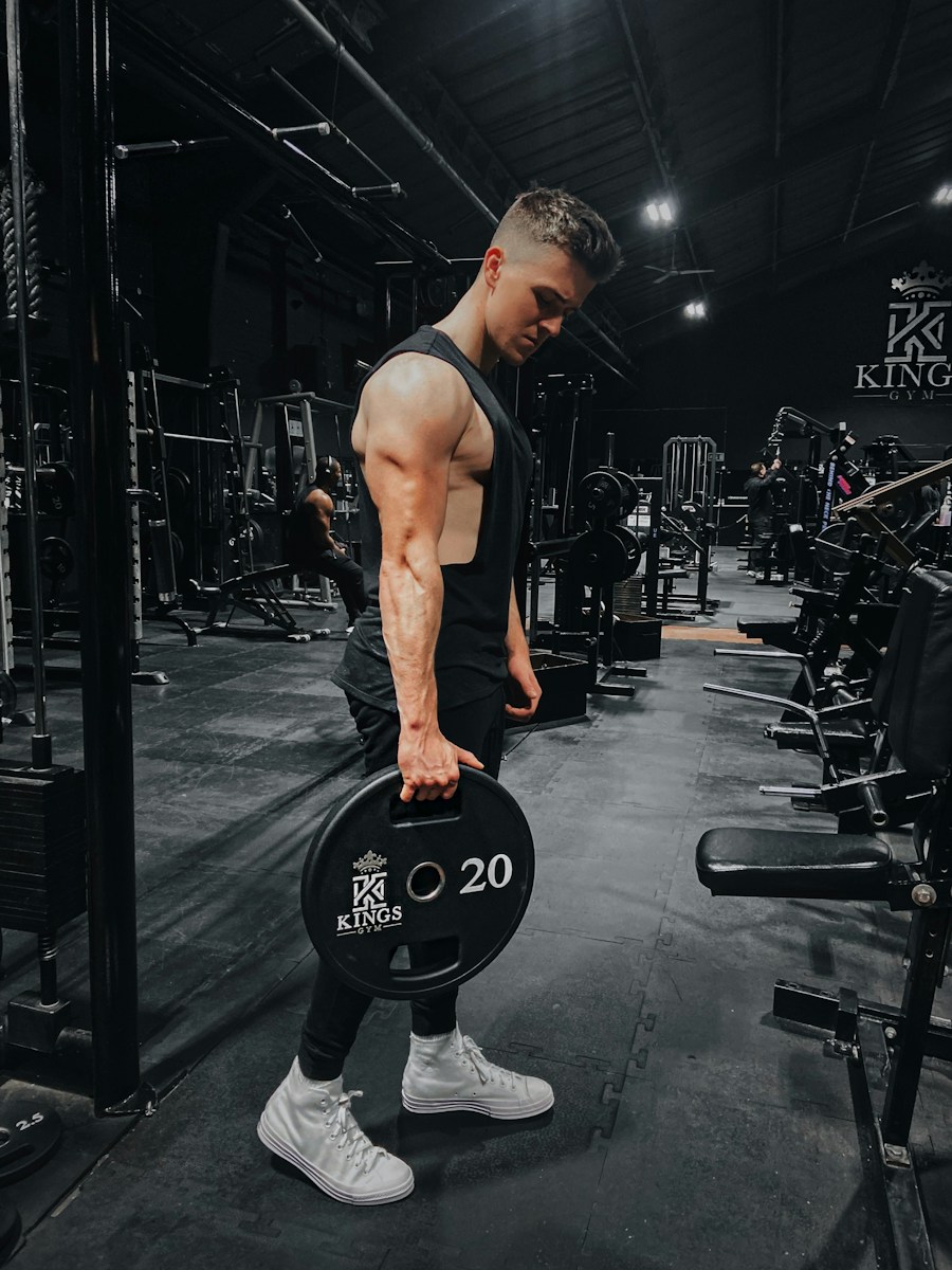 Athlete carrying a weight plate in a dark gym