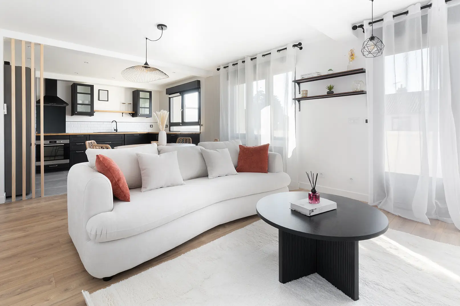 Un intérieur de maison moderne avec un canapé blanc et une table basse noir.