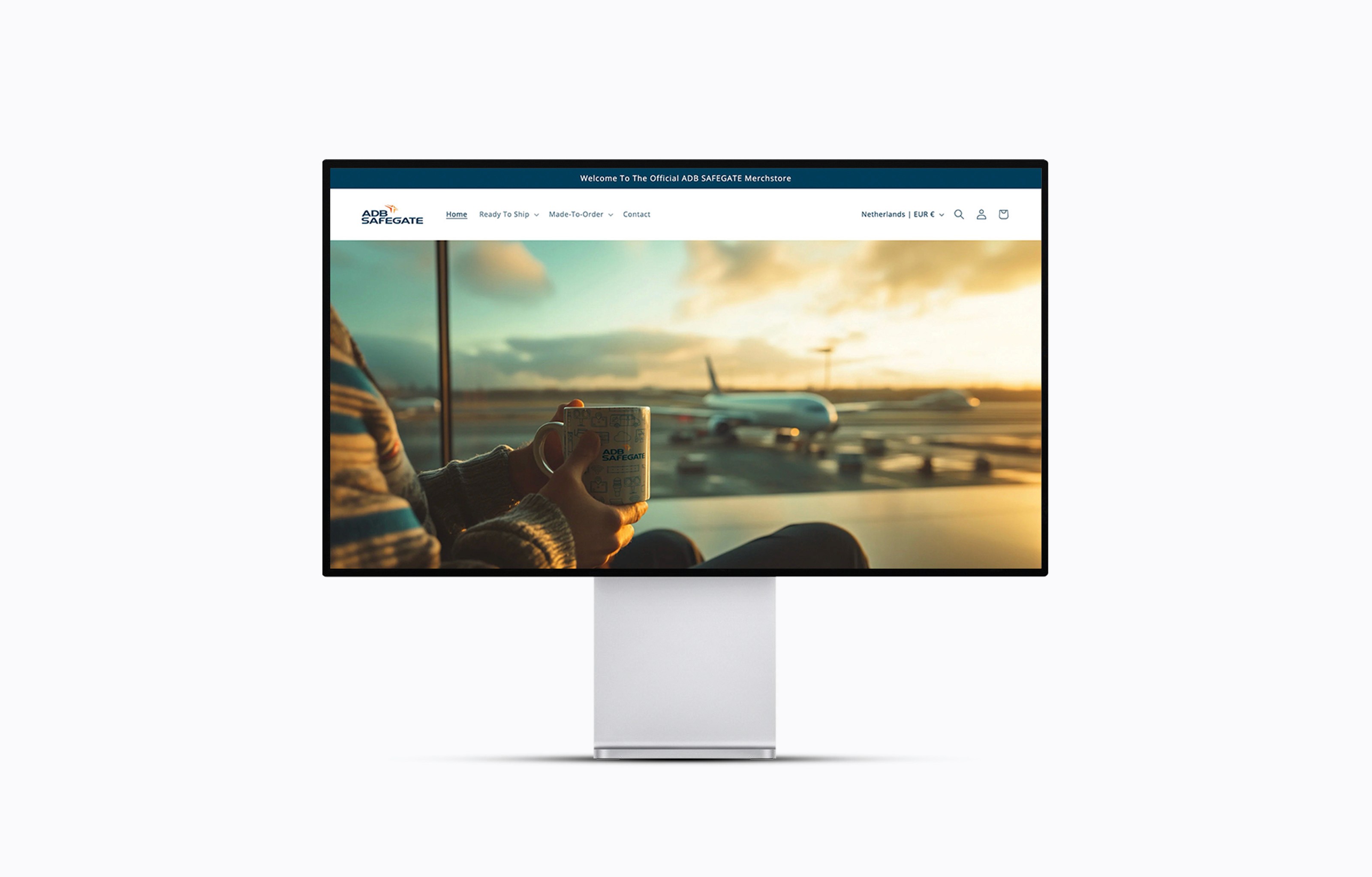 ADB Safegate company store website showing a person at an airport terminal window with a plane in the background.