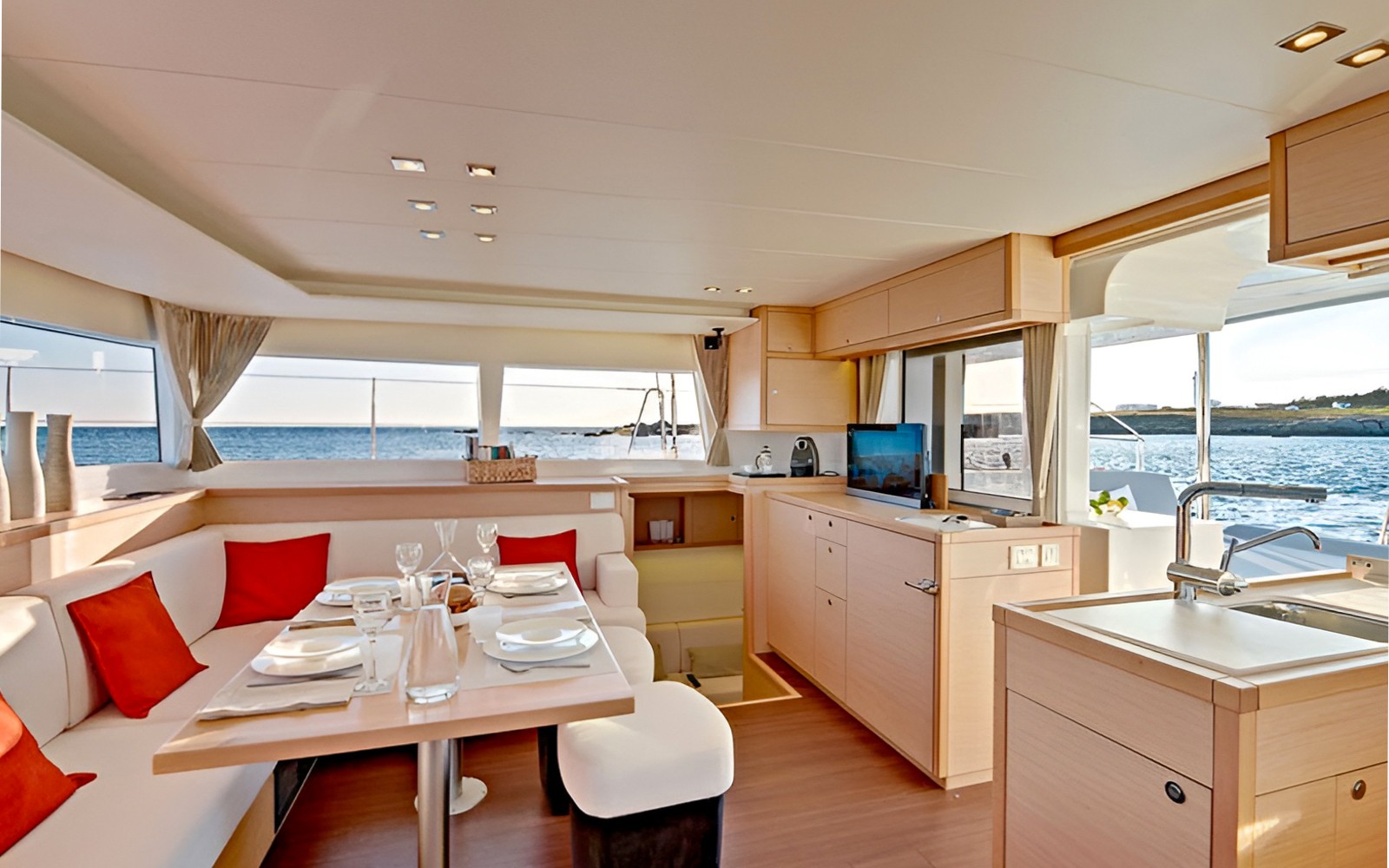 Luxury catamaran interior with dining area and ocean view.