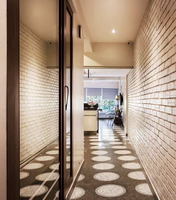 Nature-inspired preschool entrance with sculptural tree partitions and suspended green leaf ceiling panels.