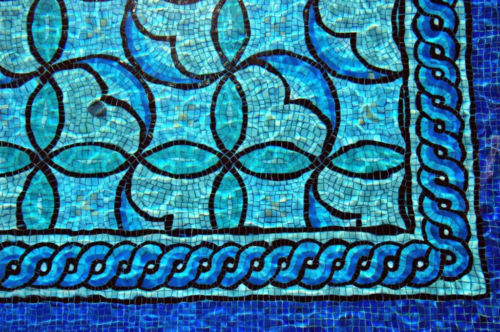 Vibrant geometric mosaic glass pool design by Mosaiclegs Art Studio.