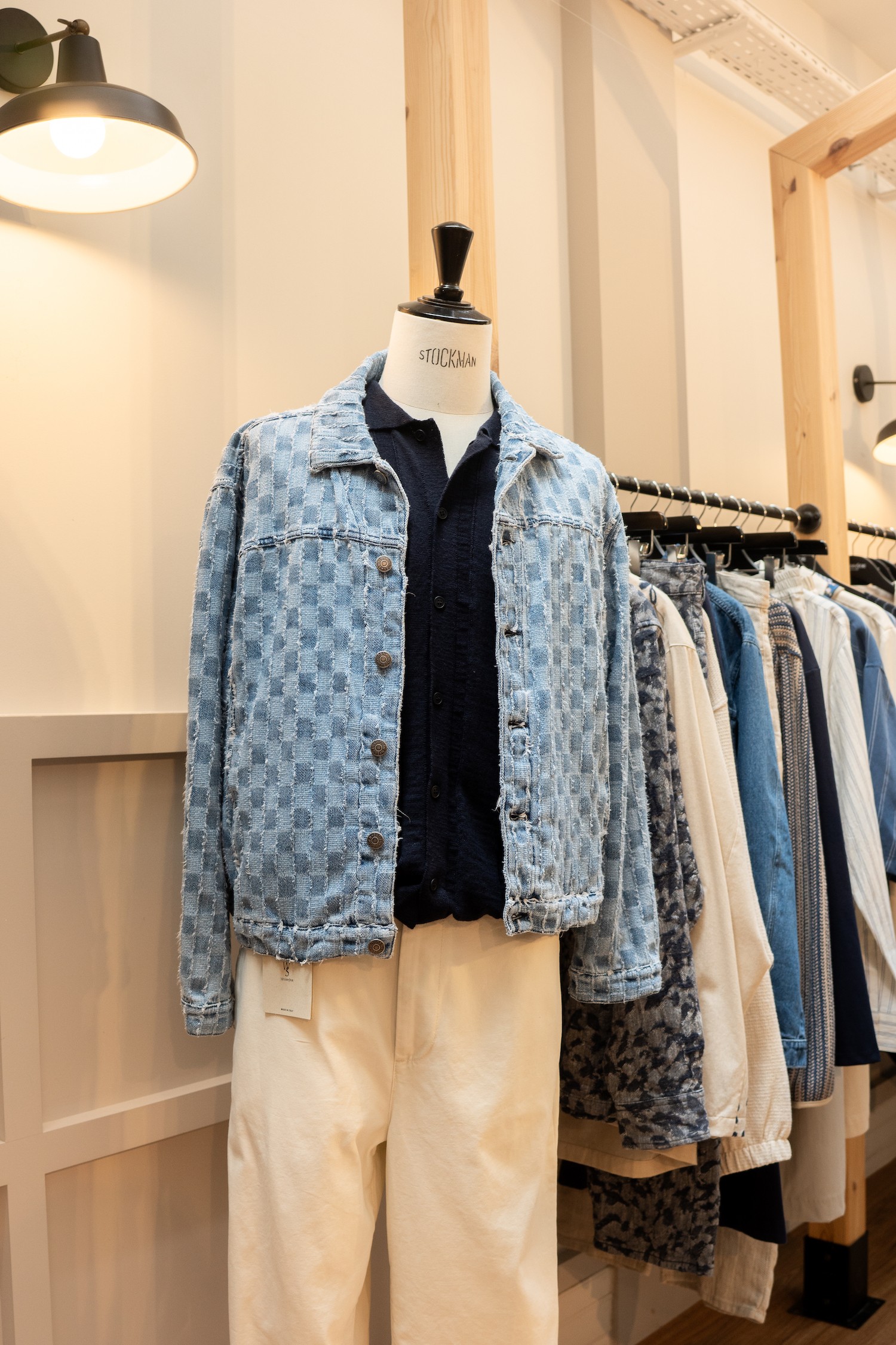 Une silhouette sur un mannequin Stockman, avec blouson en jean, chemise marine et pantalon beige