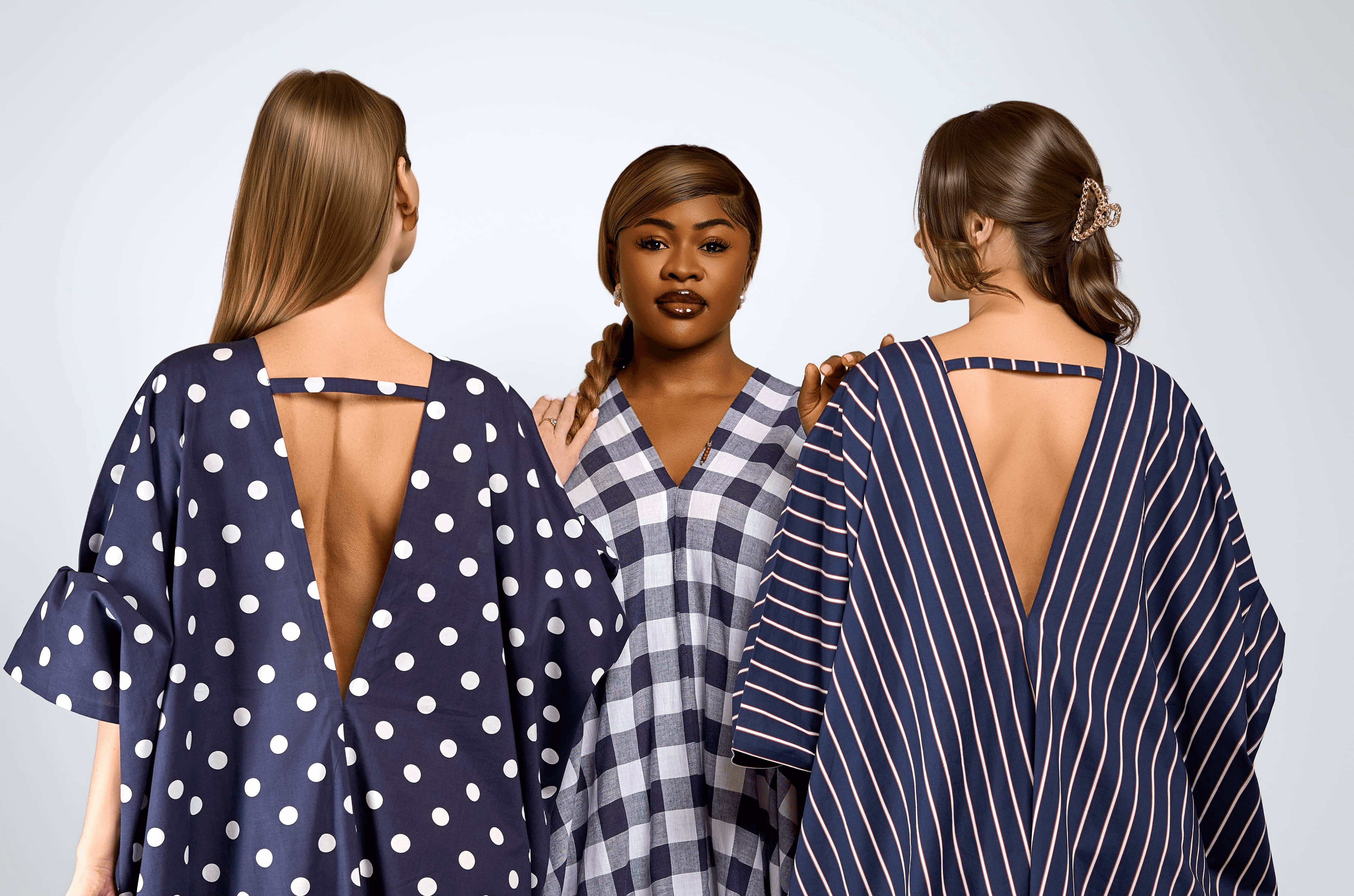 Three models standing in a wheat field, wearing beige suits.