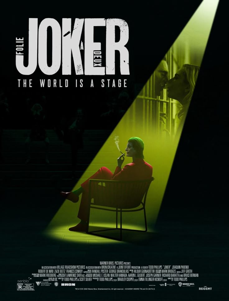 Poster for "Joker: Folie à Deux" features a person in a red suit and green hair, smoking in a chair under a spotlight. The text reads, "The World Is a Stage."
