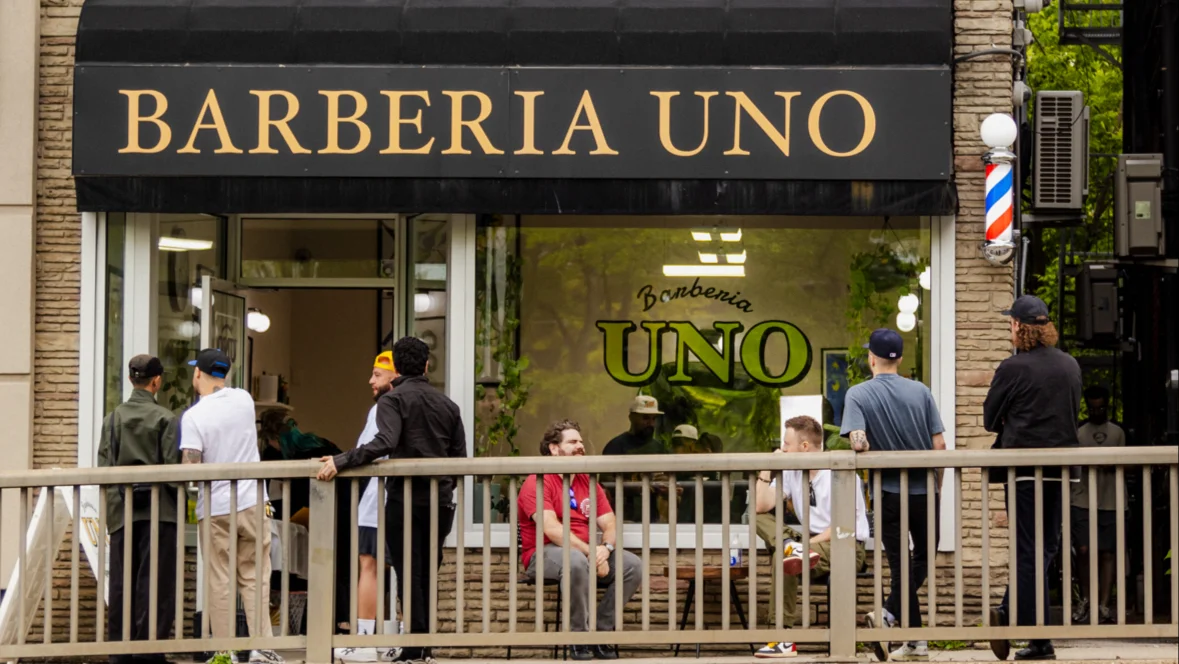 People socializing out front of Barberia Uno