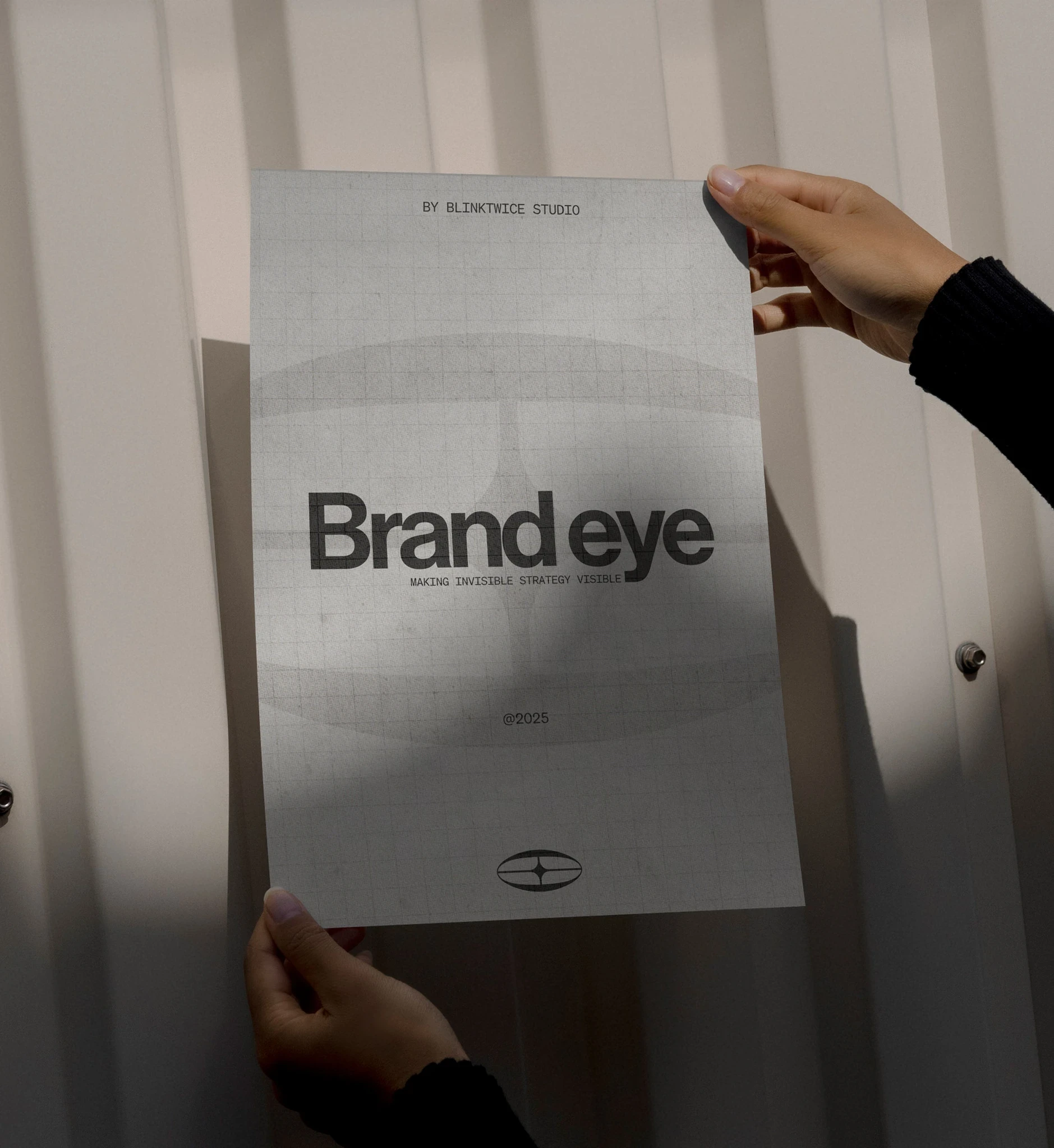Brand Eye poster held up against a white corrugated wall