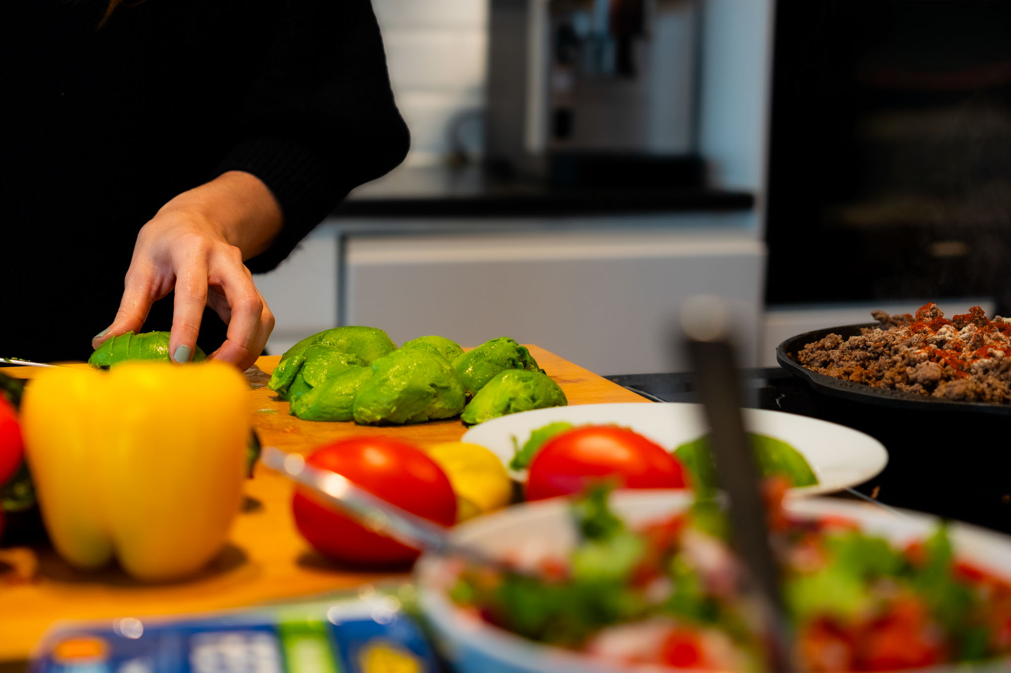 A basketball player in white guards an opponent in green holding the ball during a game.