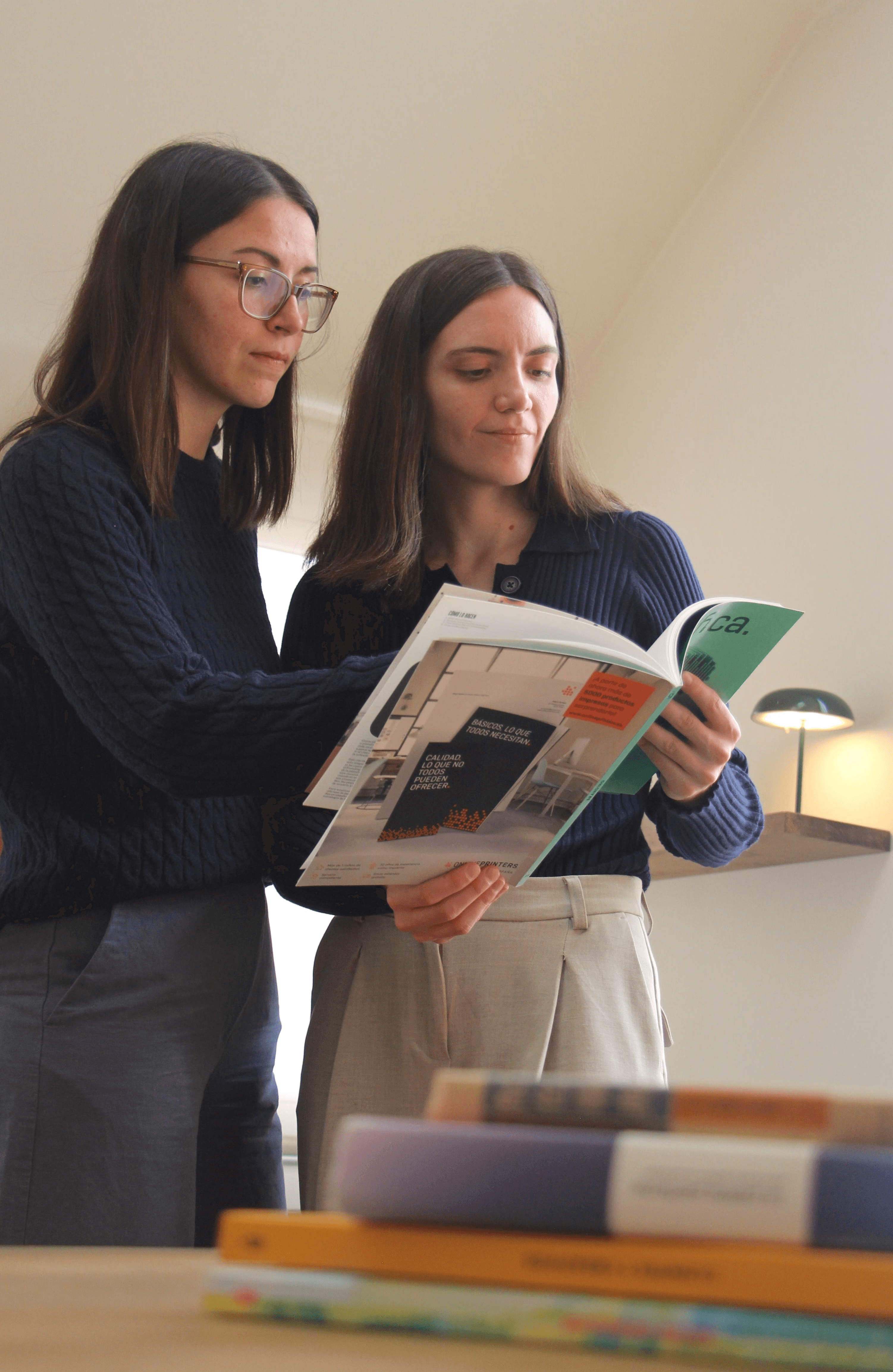 A photo of the two founders of the studio looking at a design magazine.