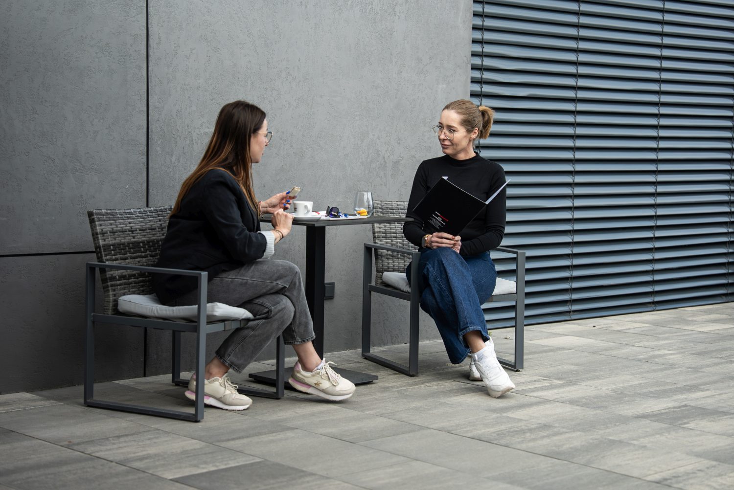 Dwie osoby omawiające materiały szkoleniowe na patio Niedźwiedzia 25