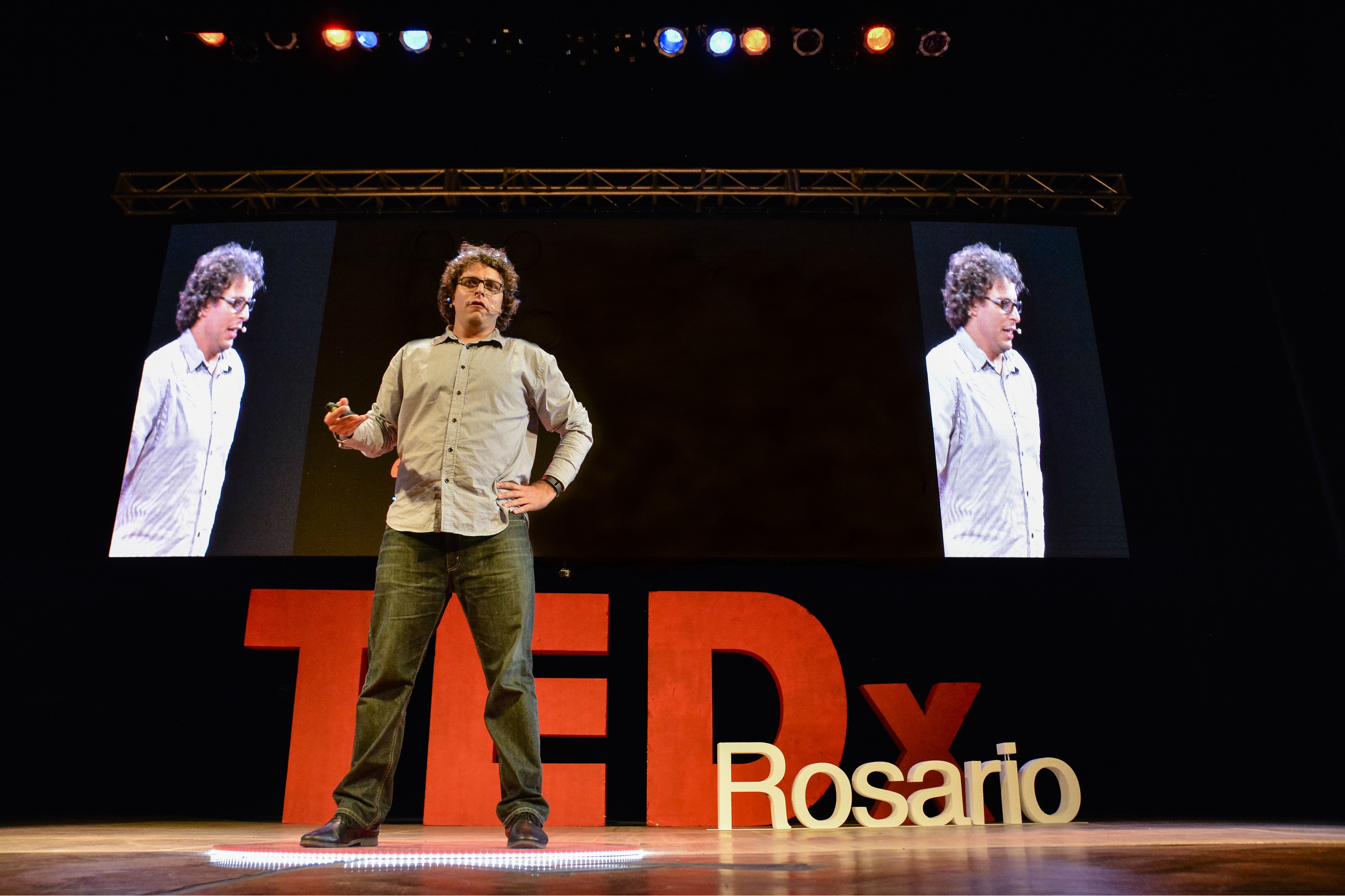 Federico Ast delivering a TEDx talk on stage about institutional innovation and technology.