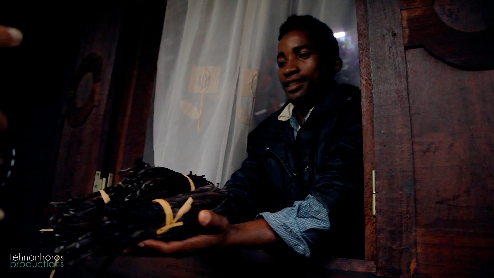 A man is holding a vanilla during the filming of a documentary about vanilla of Madagascar