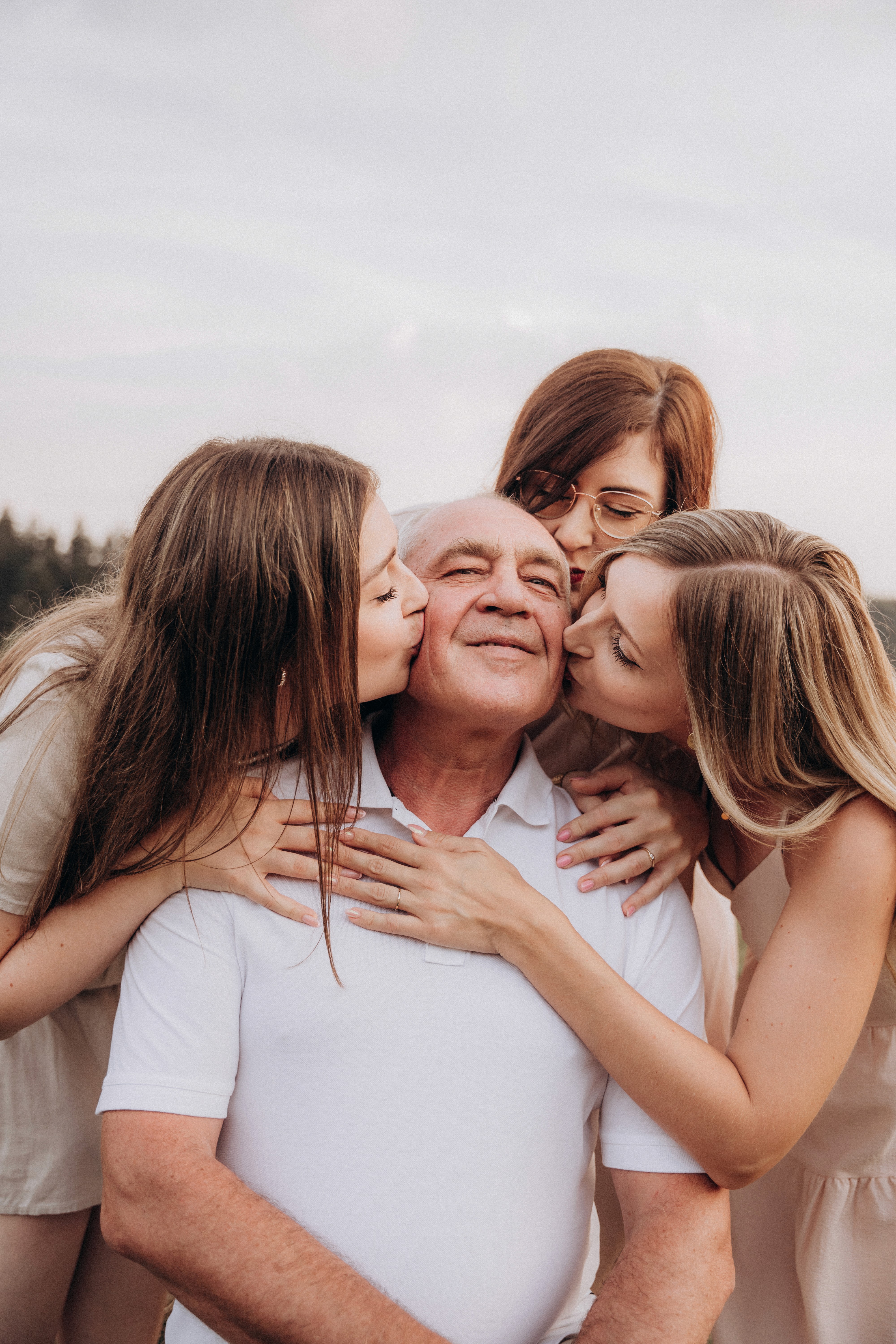 Emotionale Familienfotografie in Bogen – Töchter umarmen ihren Vater bei einem natürlichen Fotoshooting.