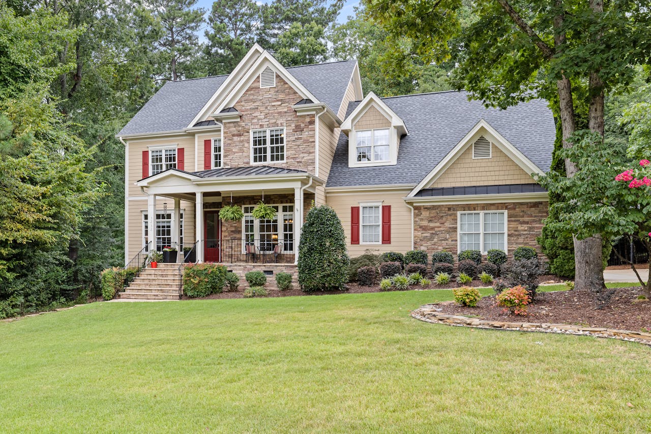 Image that shows signals the sell of a home. A hand giving another hand a key, in front a signal that "Home for Sale".