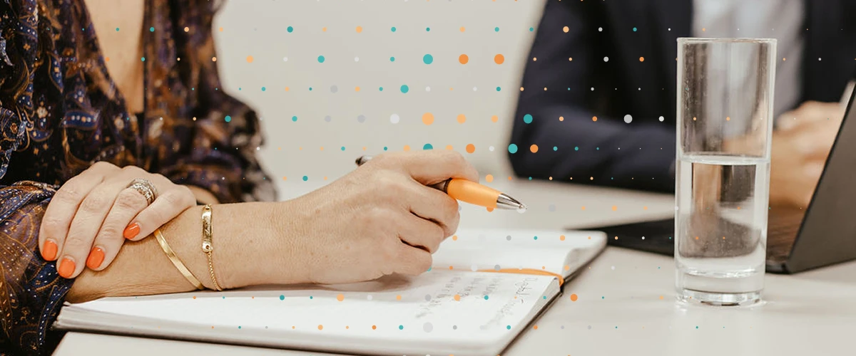Lean Tree team member writing in a branded pad with a water on the desk
